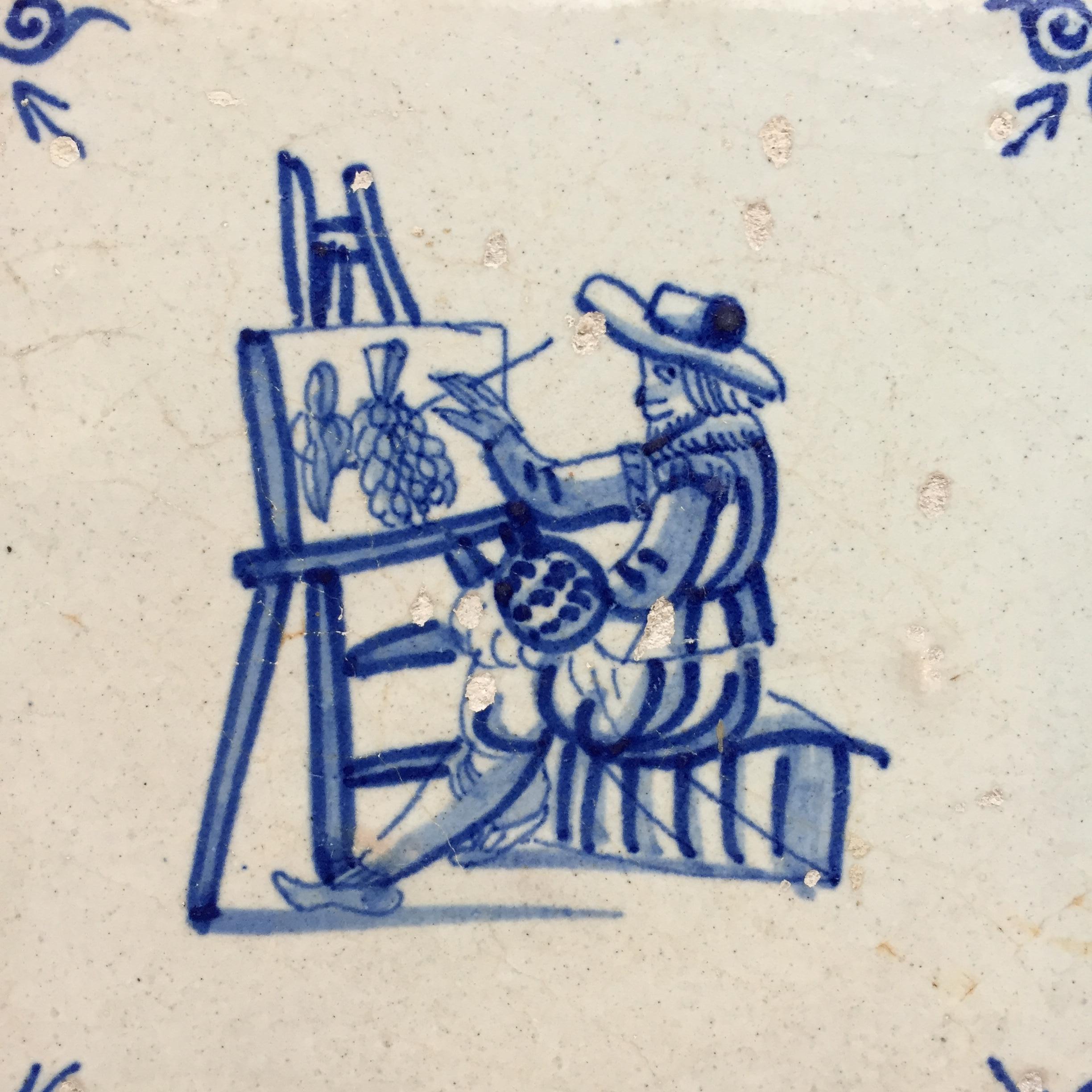 The Netherlands
Hoorn
Circa 1630 – 1660

A very rare and fine blue and white tile with the decoration of a painter in his workshop, painting a still life painting.
Very nice details of the painter his easel and his painting.
A Dutch master painter