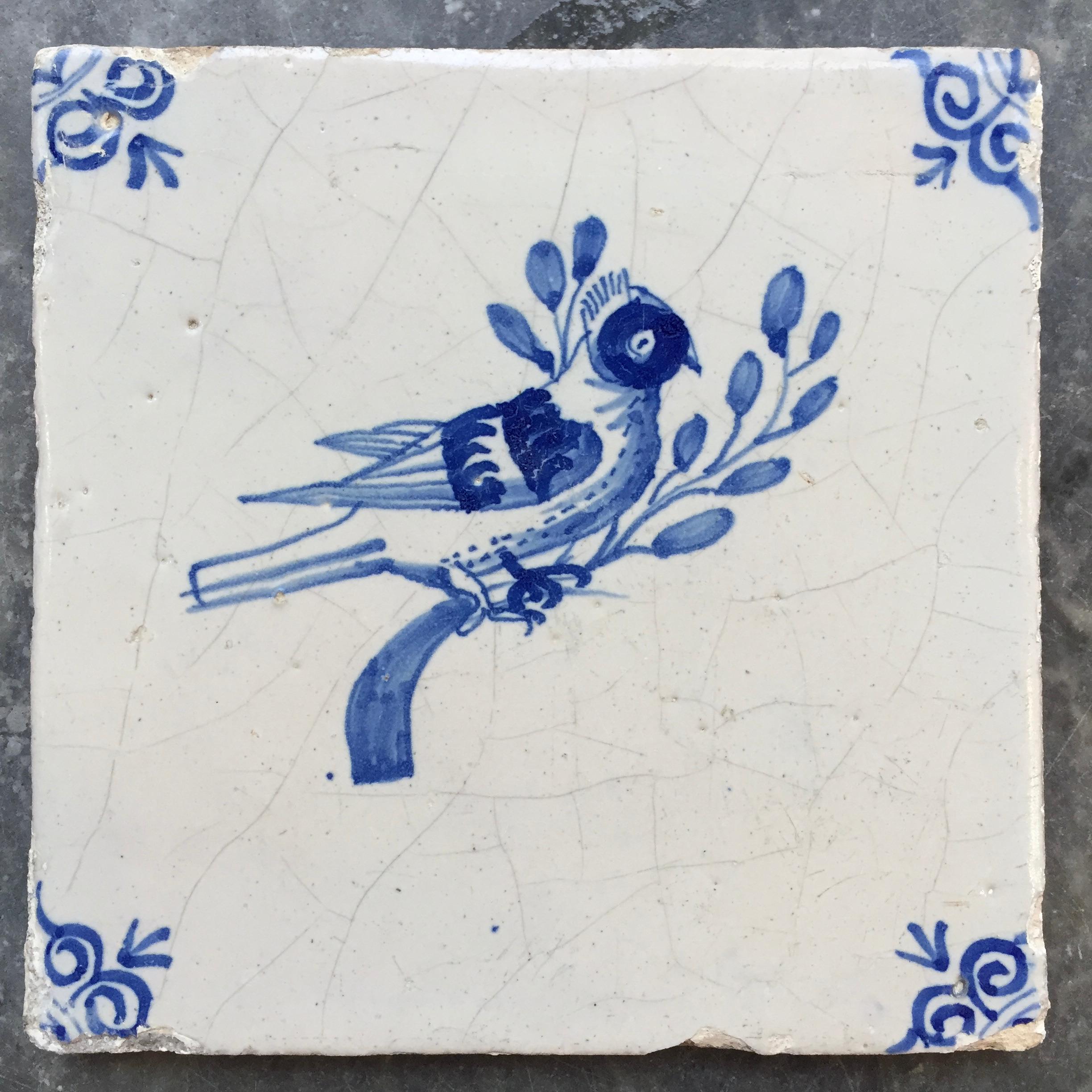 The Netherlands
Circa 1630 - 1660

A fine painted blue and white tile with a decoration of a bird on a branch.
With so-called oxheads as corner decoration.

A genuine collectible of approximately 400 years old.