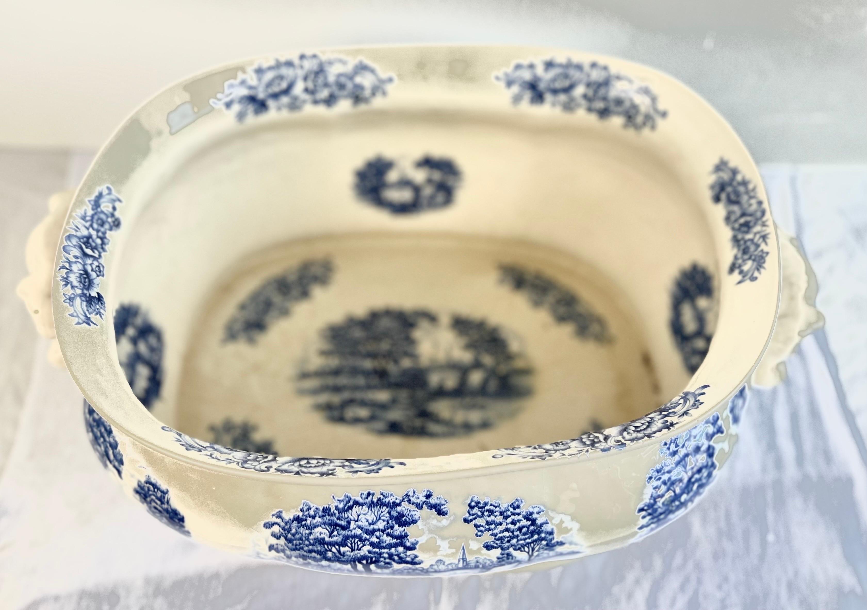 19th century oval shaped English Ttransferware cachepot.  It details blue & white pastoral european style landscape scenes throughout.   These designs are applied using a transfer printing technique, where a design is engraved onto a copper plate,