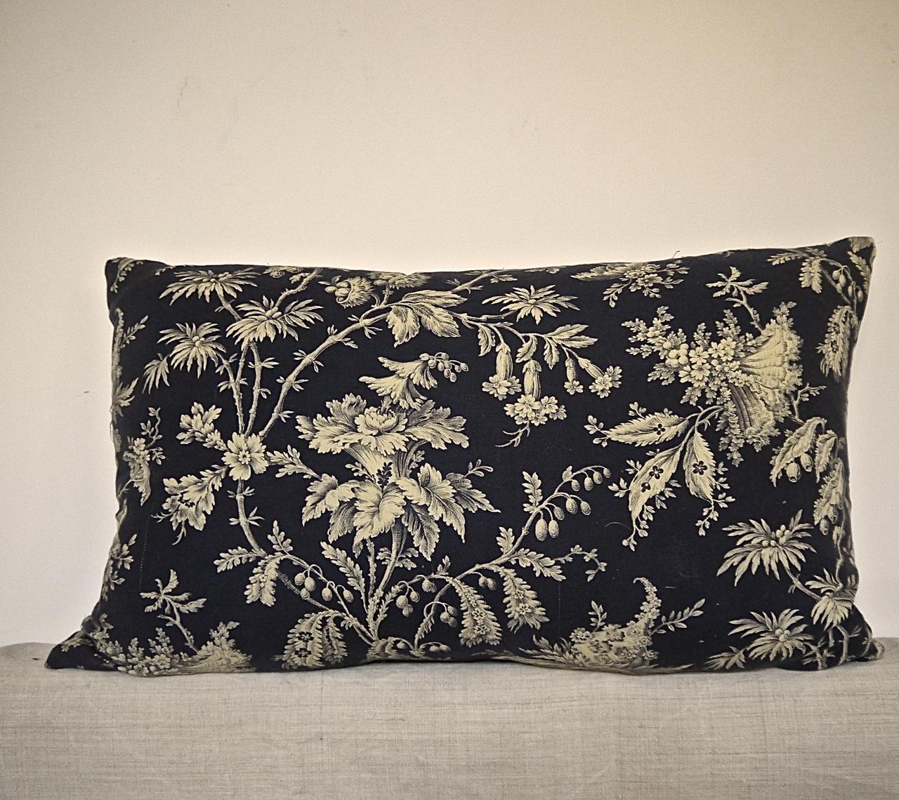 French printed cotton cushion. Printed with a design of exotic flowers and meandering branches on a textured cotton. Self-backed and slip-stitched closed with a duck feather insert, circa 1870s.