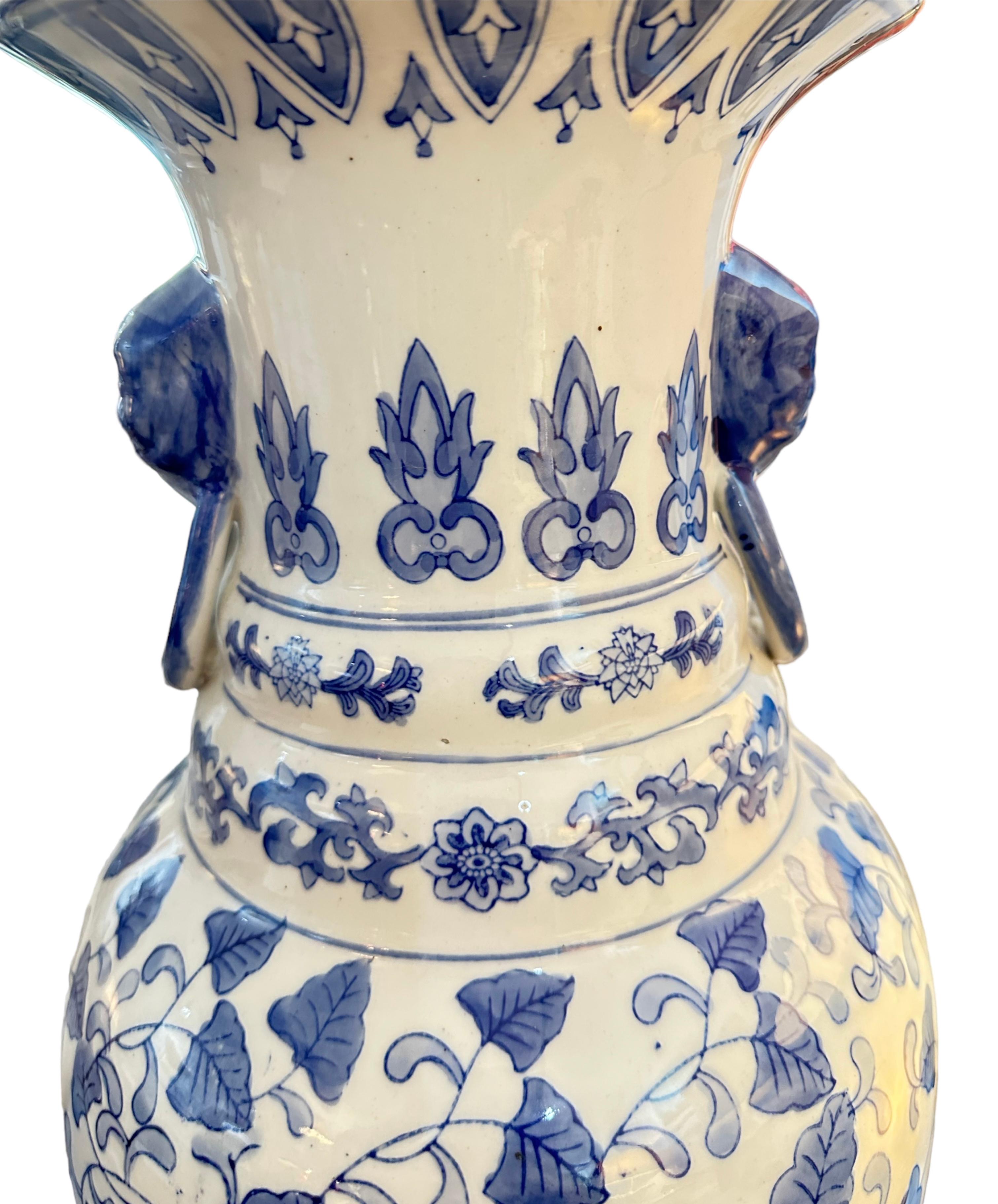 Floor vase, blue and white classic with beautiful flower with vine of leaves covering the body of the vase. More white in person.