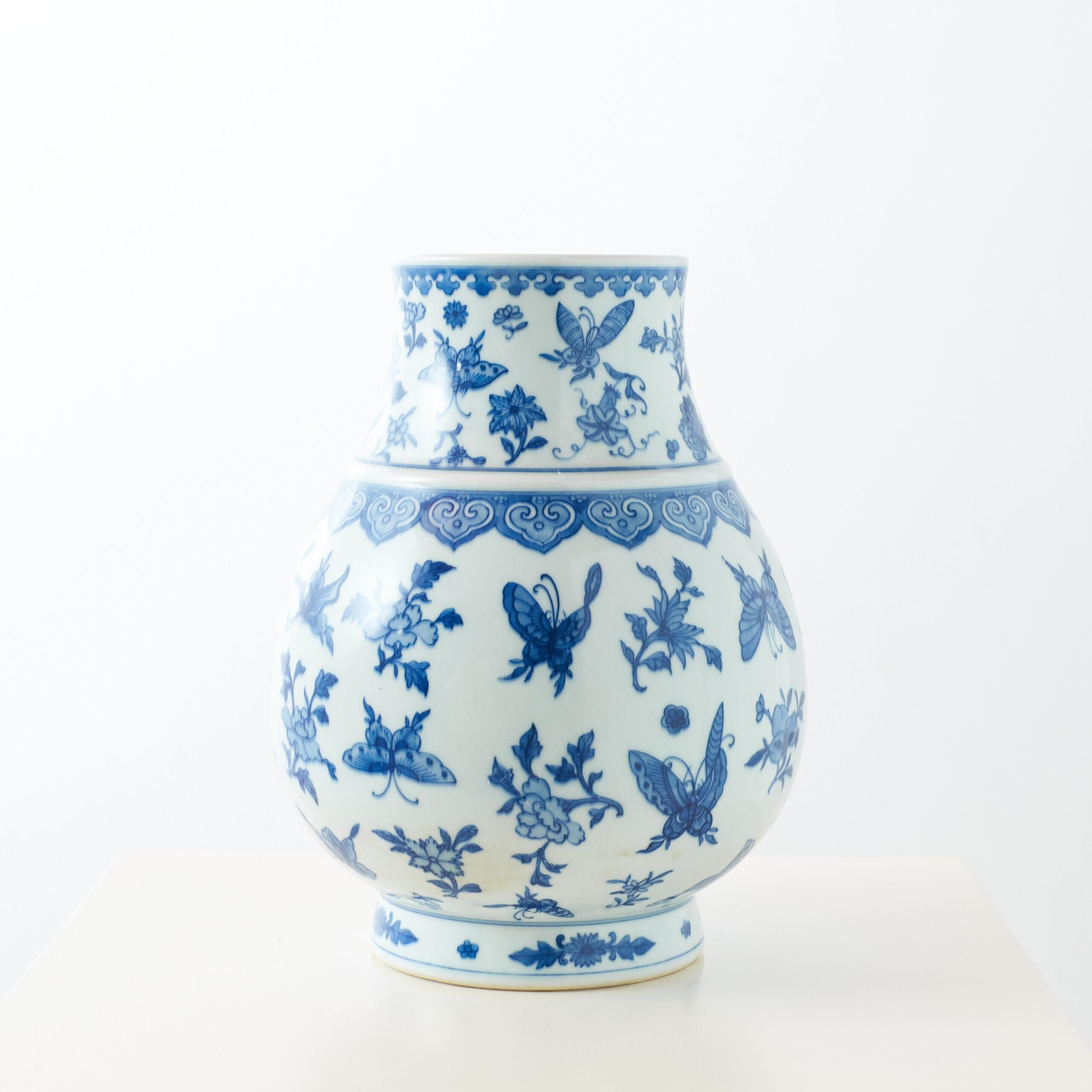 Blaue und weiße kugelförmige Vase mit Schmetterlingen und floralen Motiven

Kugelförmige Porzellanvase im Qianlong-Stil mit schmalem Hals, leicht ausgestellter Mündung und kurzem Fuß. Der Körper ist in Blau und Weiß mit Schmetterlingen und