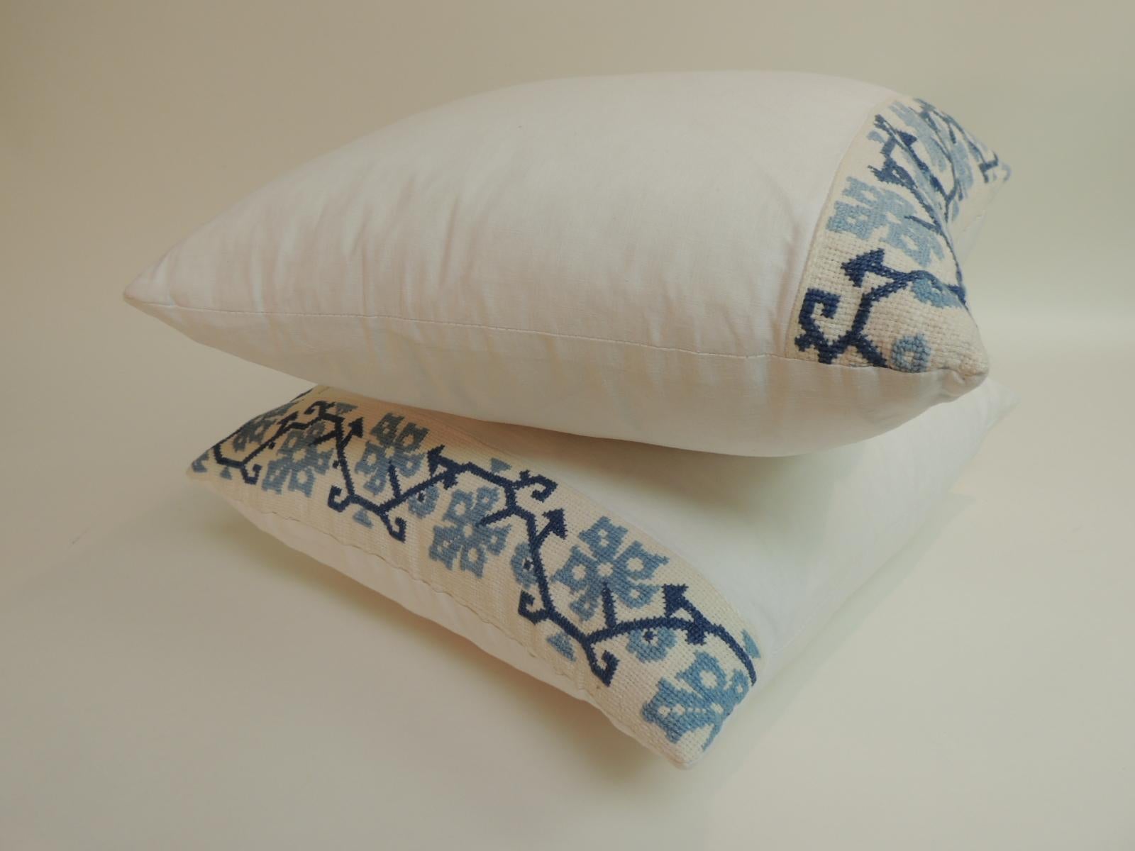 Blue and white Greek isle embroidered decorative pillows. 
Blue and white cross-stitched embroidery border on to white linen.
 White cotton backings. Accent pillows handmade and designed in the USA. 
Closure by stitch (no zipper) with custom made