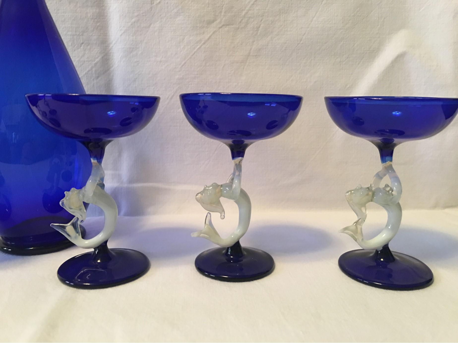 A lovely blue and white 1950s Mermaid Liqueur set in the beautiful Bimini style. The handle and tops are depictions of a Mermaid. Since every glass is handmade there are minuscule differences in each glass. The Carafe is 9.25 inches high with a