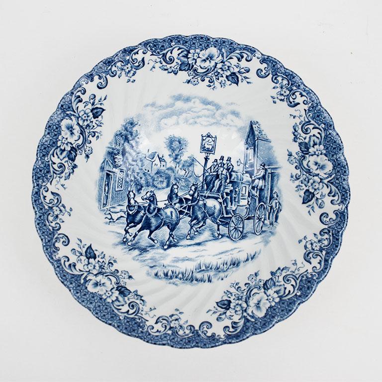 A lovely blue and white English serving bowl with a fluted body and pattern on the inside. The inside features a blue painting of a carriage scene with horses and coachmen. 

Bottom reads:
Two seals at the top
By appointment to her majesty the