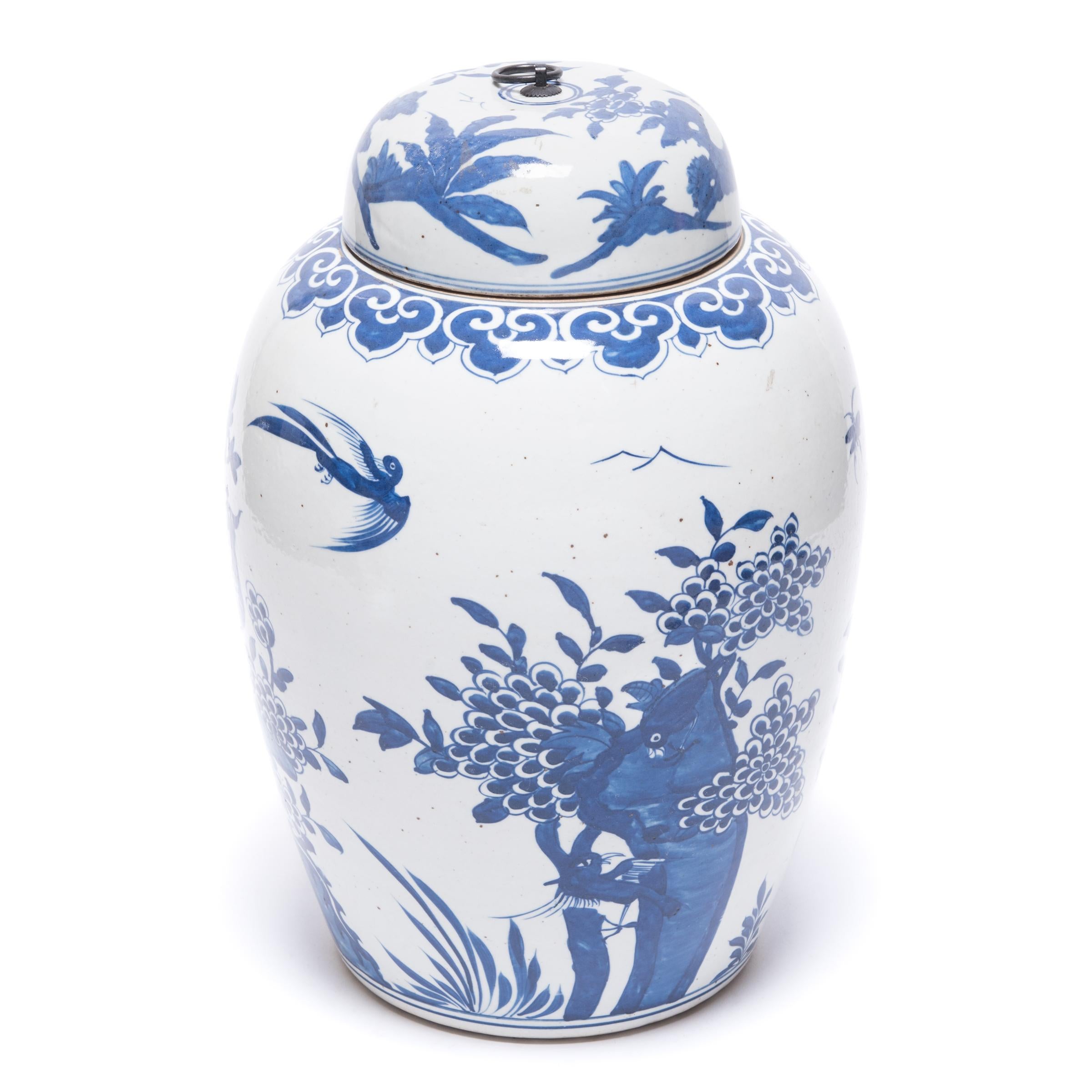 Conçue pour conserver les feuilles de thé, cette jarre n'en est pas moins un exemple étonnant de porcelaine bleue et blanche. Entourés de pivoines et de chrysanthèmes en fleurs, deux phénix sont perchés sur un affleurement rocheux. Le plumage du