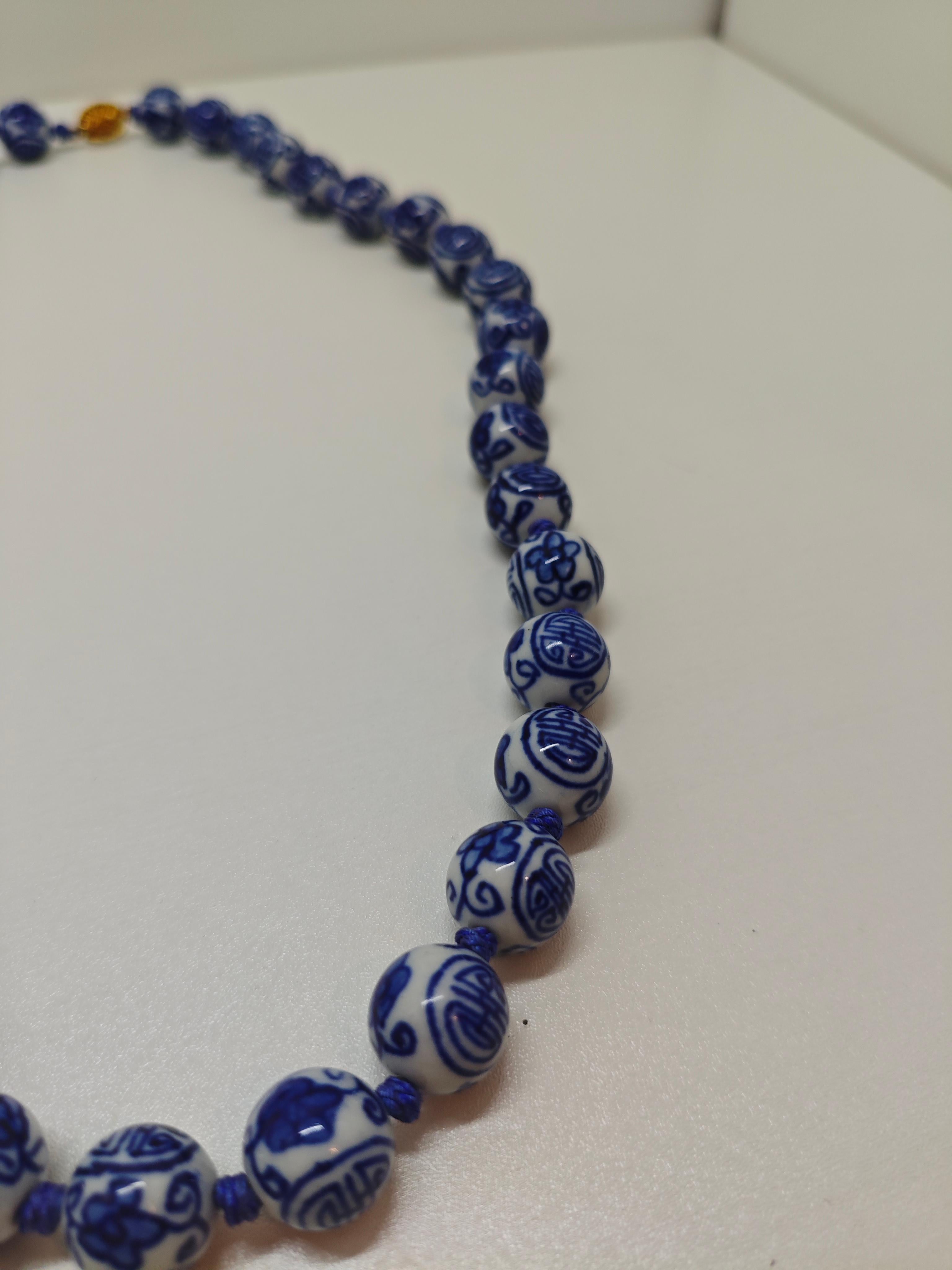 Celebra l'eredità e l'eleganza con questa collana di perline di porcellana bianche e blu realizzata durante la seconda guerra mondiale, intricata con il tradizionale motivo cinese della longevità (寿). Ogni perlina cotta in forno ad alta temperatura