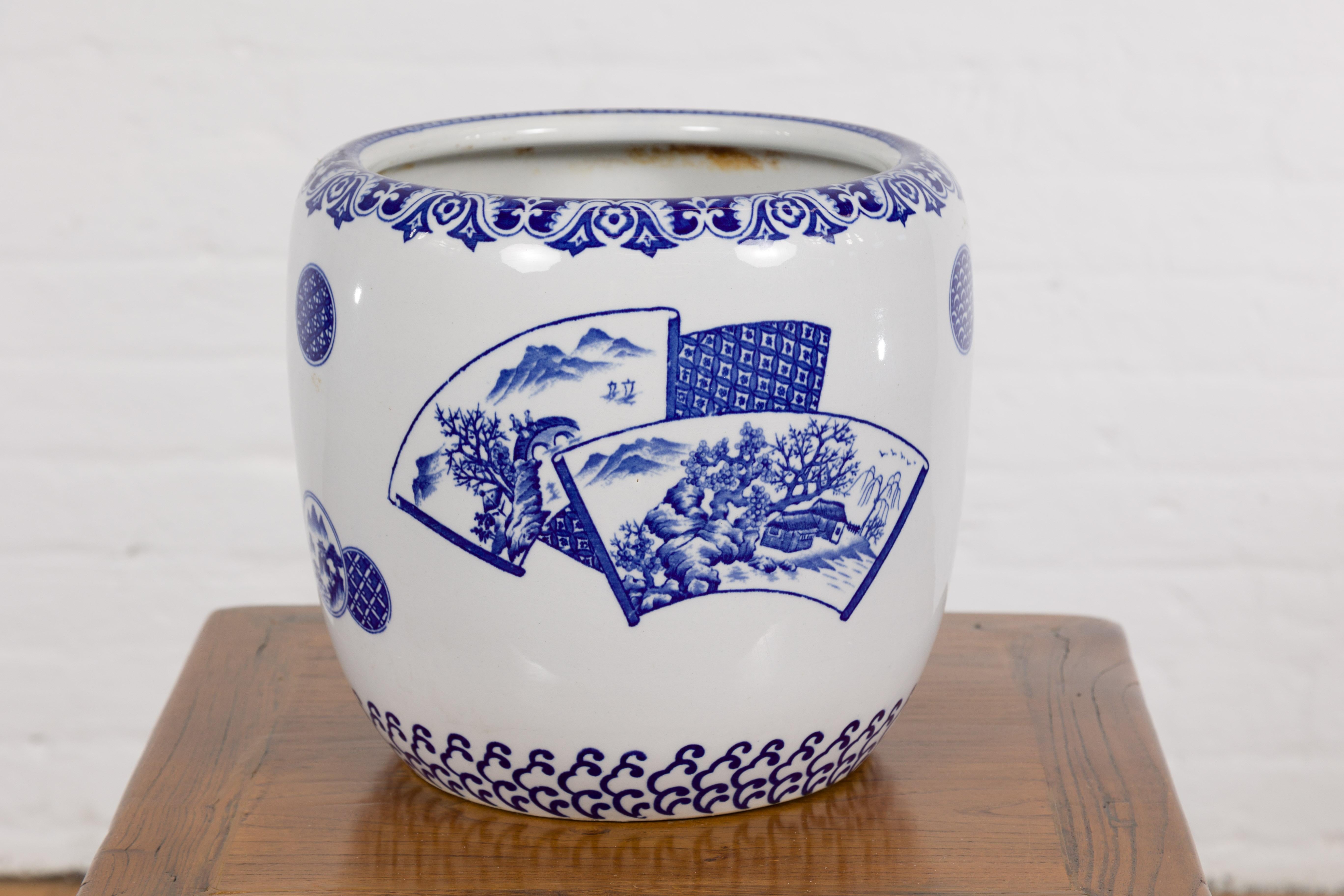 A vintage Chinese blue and white porcelain planter with hand-painted landscape design. Gracefully encapsulating the serene beauty of Chinese landscapes, this vintage blue and white porcelain planter transforms any space into a peaceful haven. Its