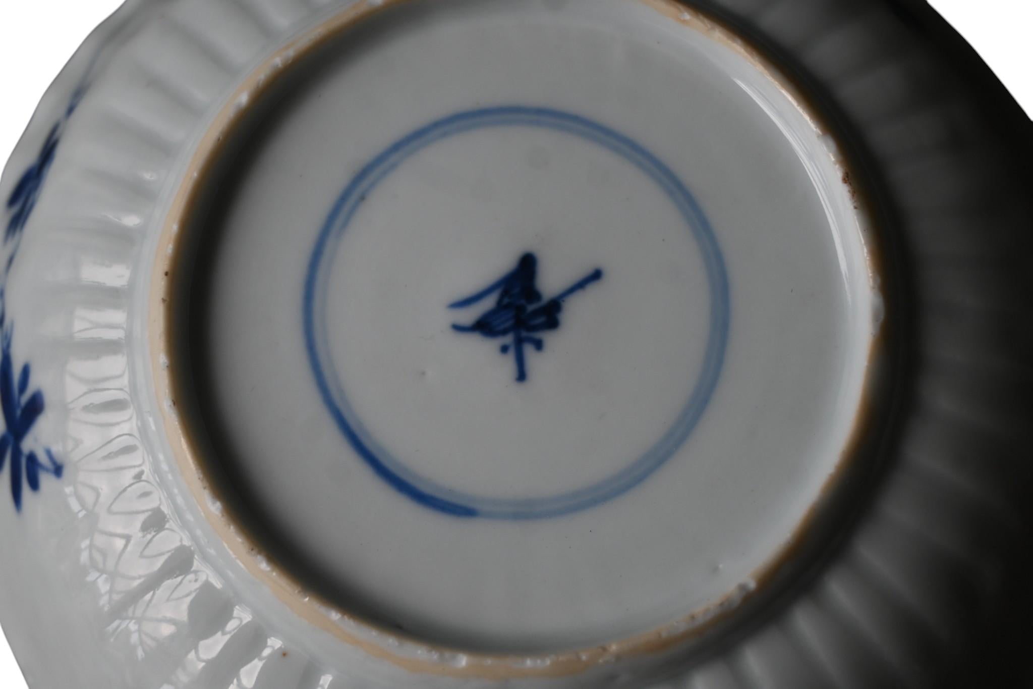 Chinesisches blau-weißes Porzellangeschirr - Kangxi-Periode (1662-1722)
Zarte, gerippte Porzellanschale, fein gemalt in kobaltblauer Unterglasurmalerei mit floralen Motiven von Pfingstrosen und Blattwerk. Das Innere zeigt ein zentrales Medaillon mit