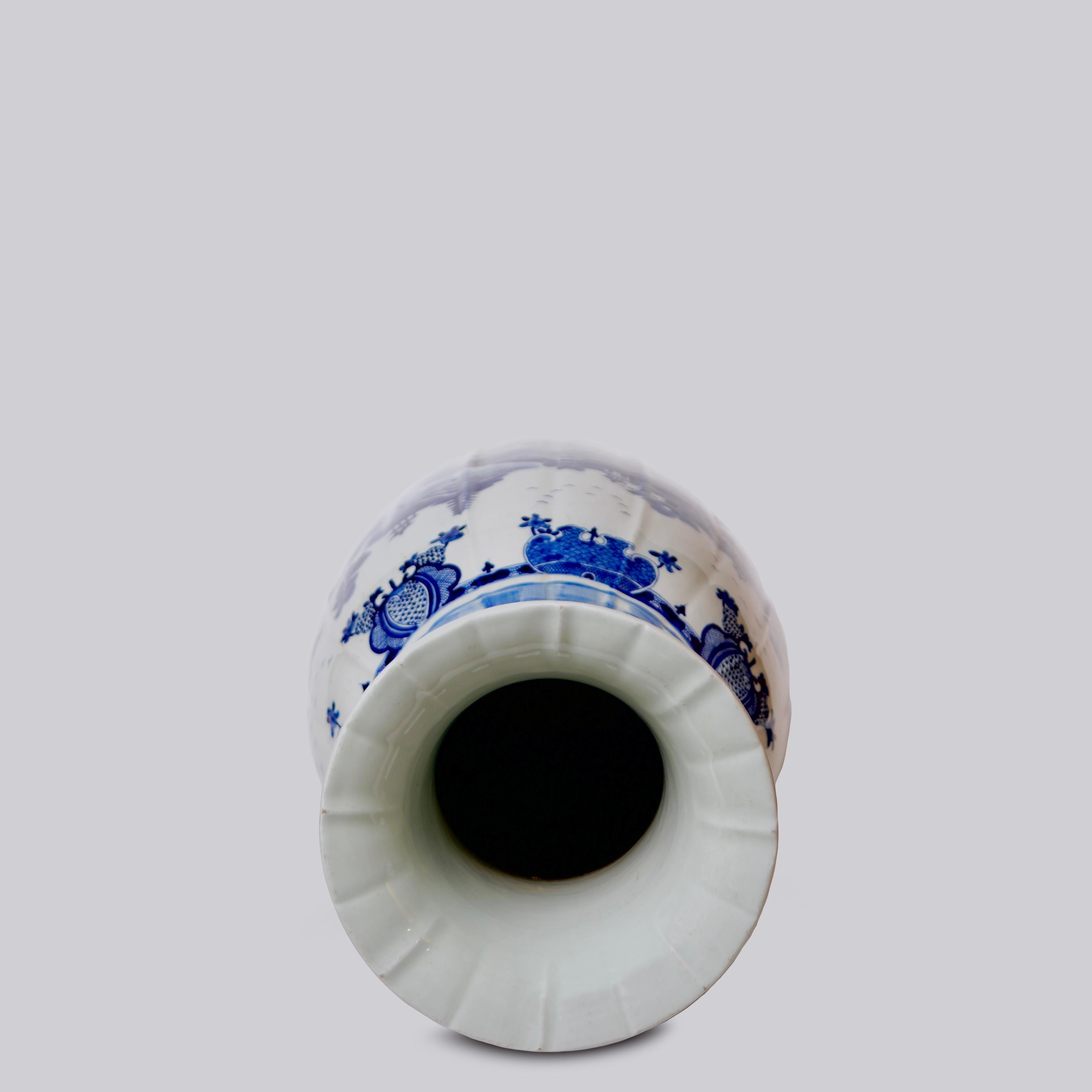 This temple jar is a traditional porcelain vessel from Jingdezhen, a town long distinguished by imperial patronage. This piece is a porcelain vase with a design reminiscent of the famous Willow Ware pattern, accented by gourd-like vertical ribbing
