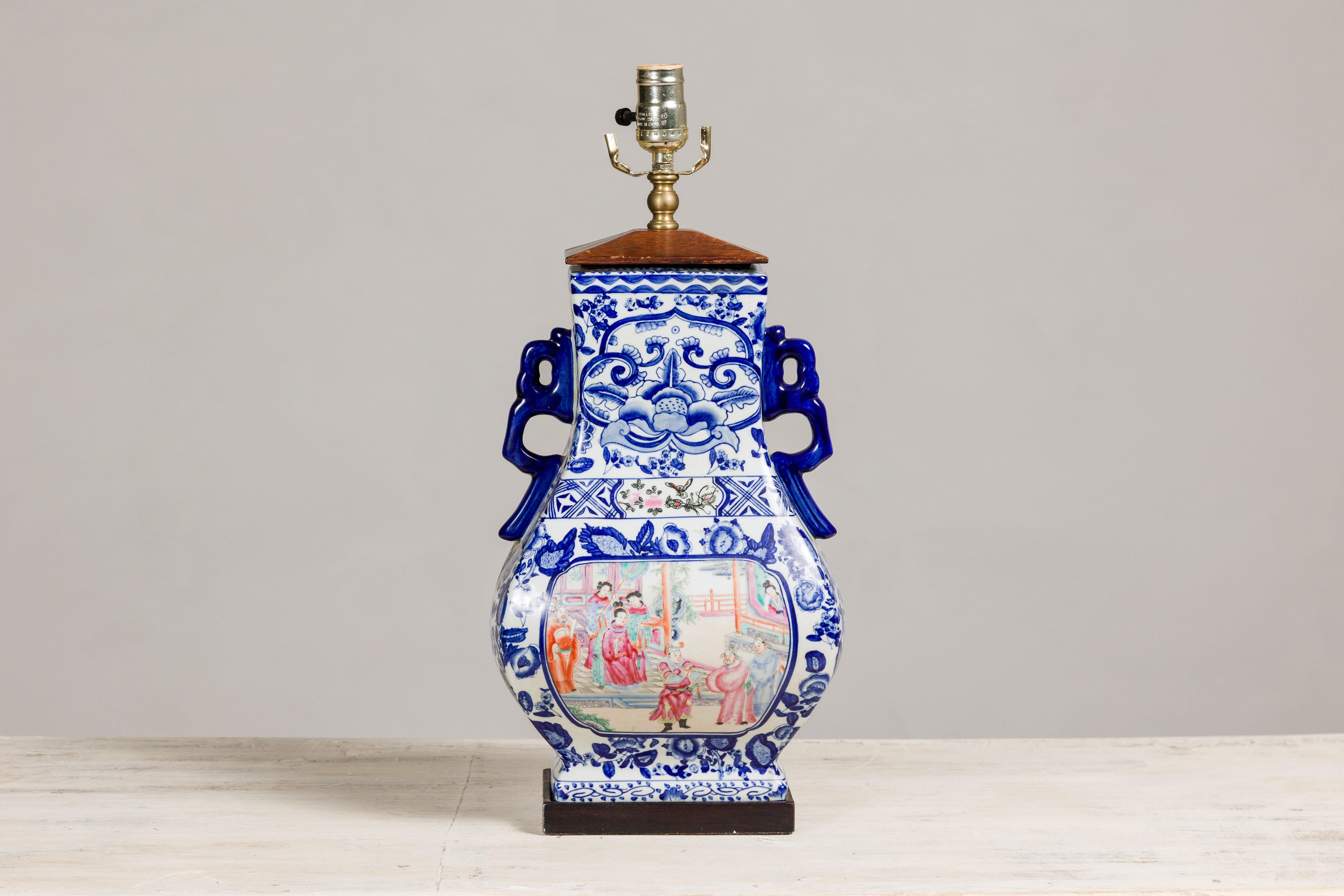A vintage blue and white porcelain table lamp with colorful hand-painted court scenes on the belly. This vintage blue and white porcelain table lamp is a true testament to the timeless beauty of hand-painted artistry. Its elegant design features