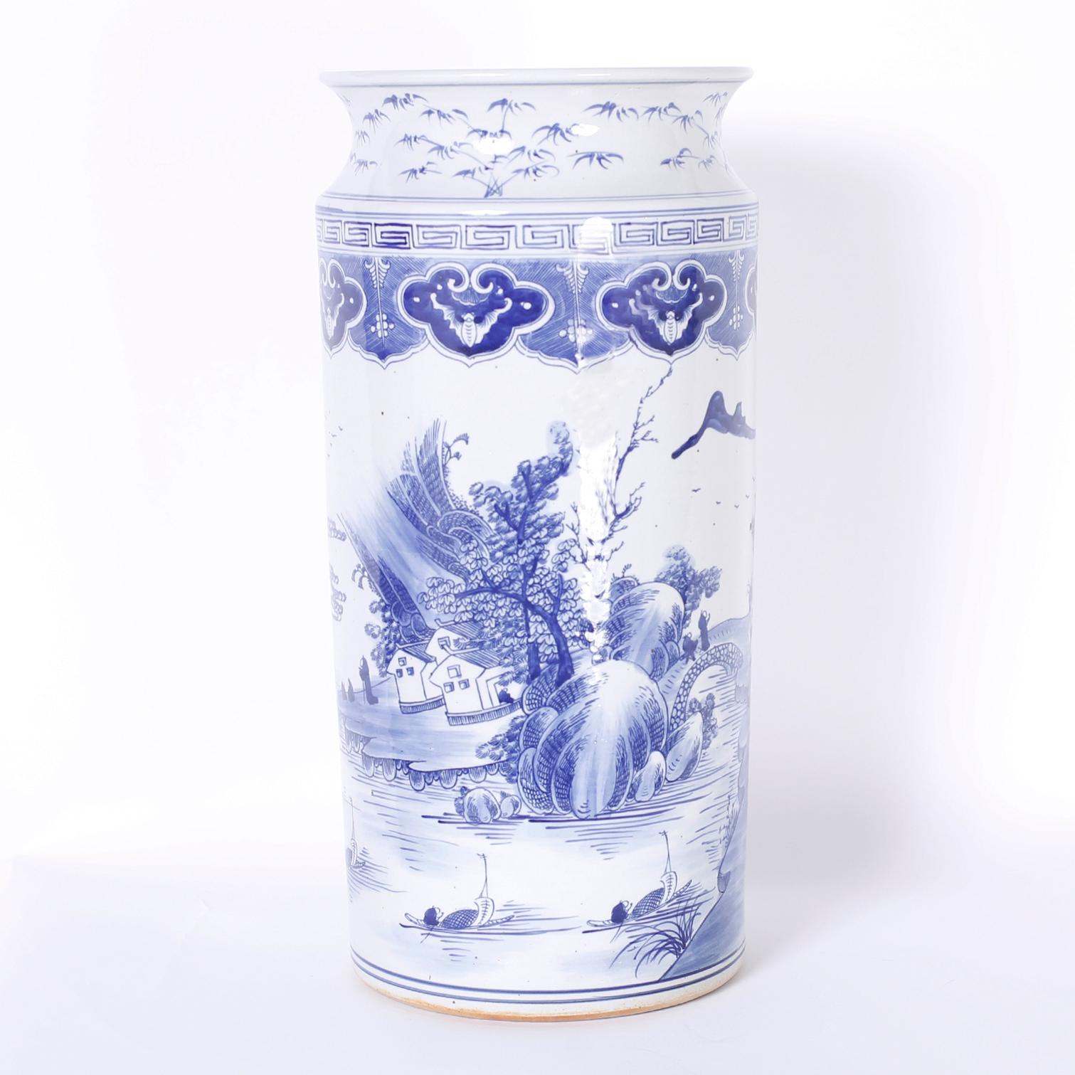 Unusual Chinese blue and white porcelain umbrella stand hand decorated with landscapes depicting trees, buildings, and waterways.