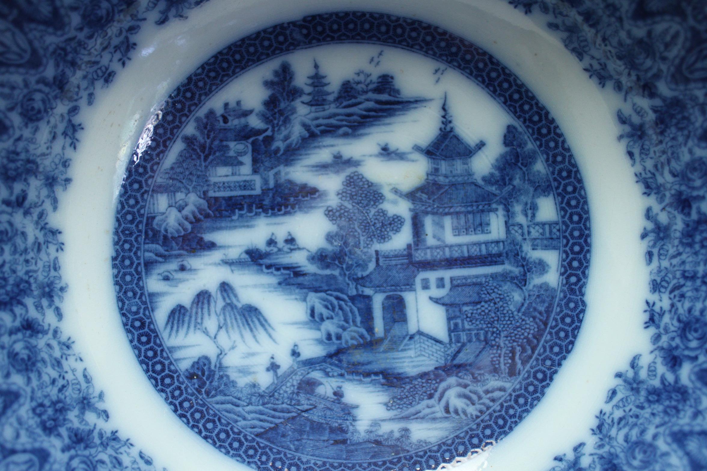 Décoré d'un motif de chinoiserie bleu et blanc sous glaçure, ce bol à punch en faïence a été attribué à la manufacture Herculaneum de Liverpool. La bordure inhabituelle et étonnamment profonde est imprimée à l'intérieur et à l'extérieur et mesure