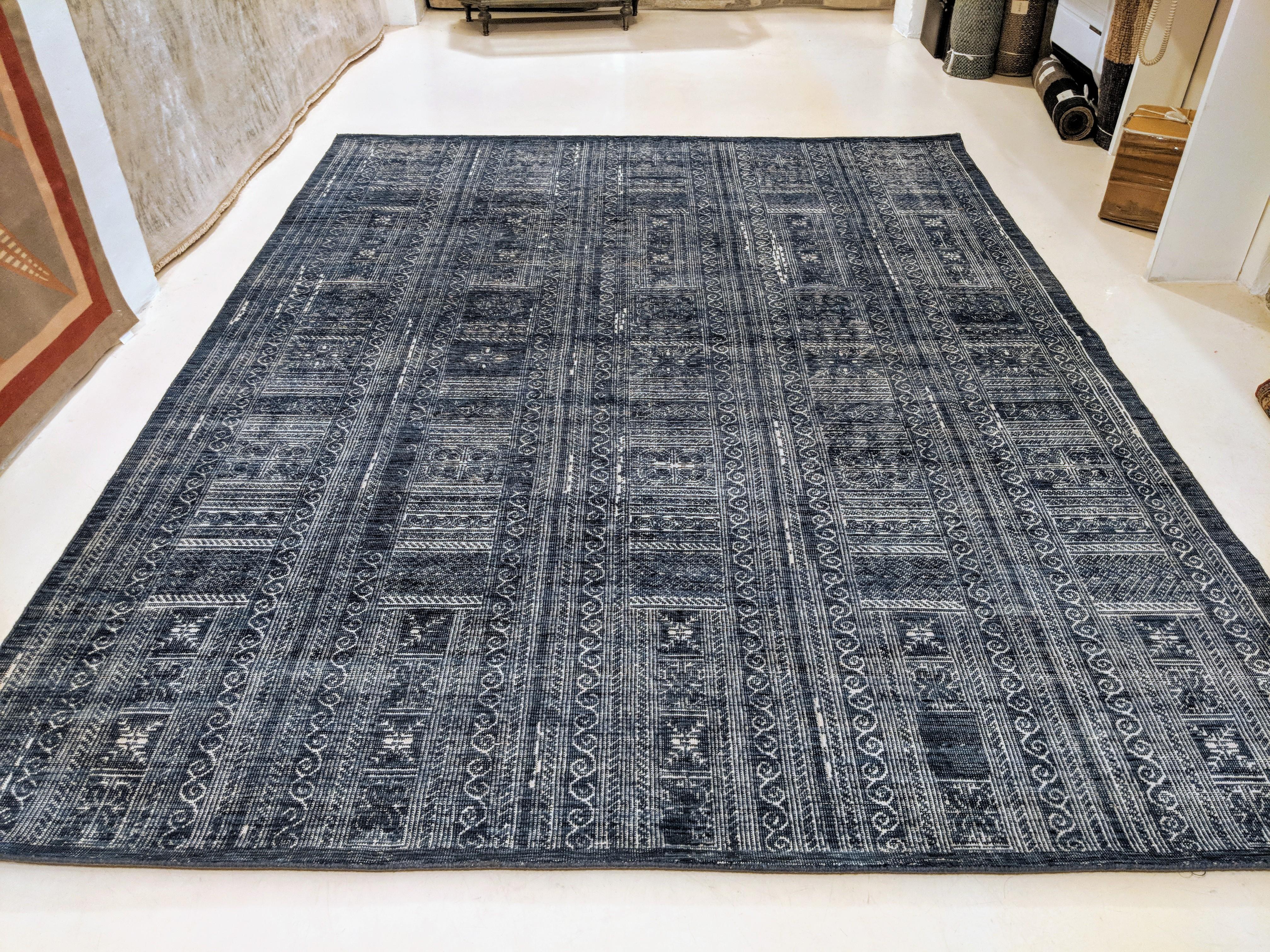 Inspired by ancient Byzantine mosaics, this rug is distinguished by an infinite repeat geometric pattern composed of intricately drawn ivory elements on a denim blue background. The carpet's pile is sheared quite low in order to adequately mimic the