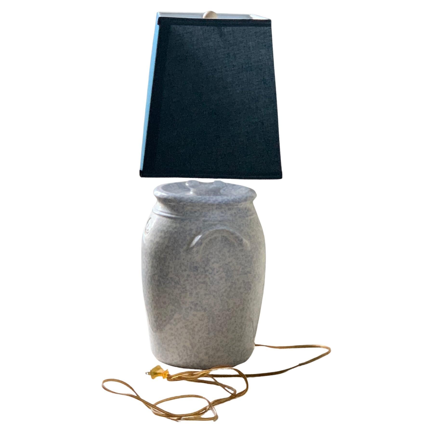 Urn table lamp with dark blue lamp shade.