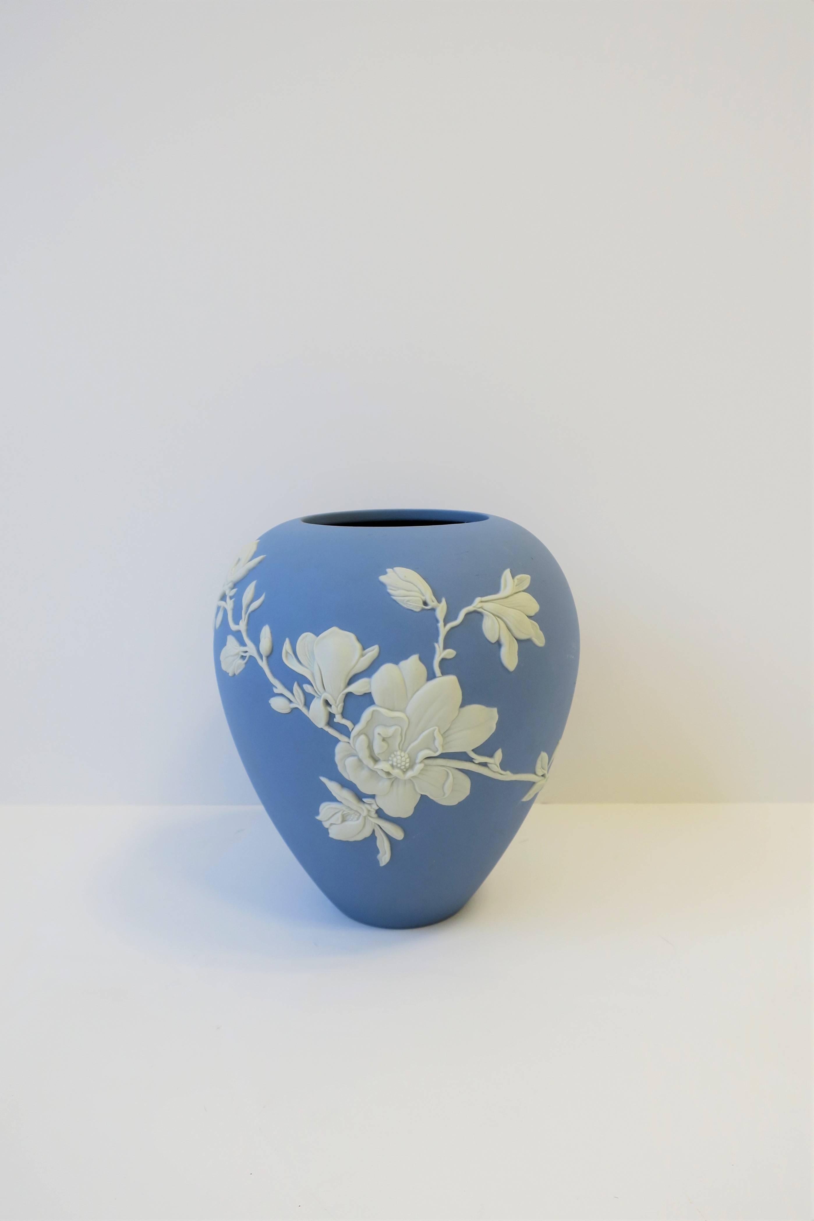 A beautiful blue and white matte Jasper stoneware Magnolia Blossom vase, by Wedgwood, England, 21st Century. Vase combines the familiar soft blue Jasper color palette with an organic shape and elegant white Magnolia flower in ornamental relief.