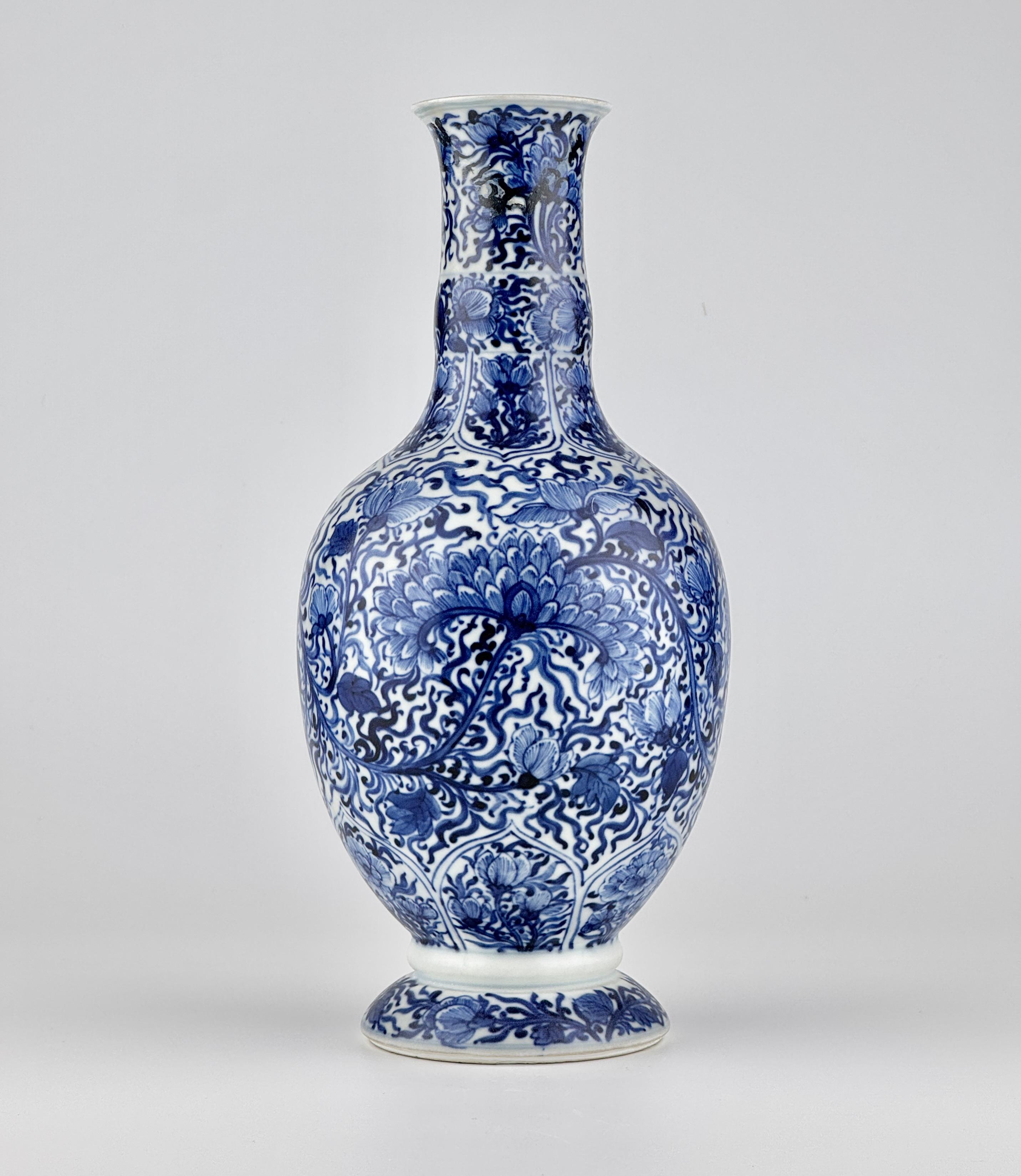 The entire surface of the vase is adorned with elaborate chrysanthemum motifs, elegantly connected by flowing, curved stems, while the background's leaf patterns enhance its sense of vitality. The rich cobalt blue coloration and evenly applied glaze