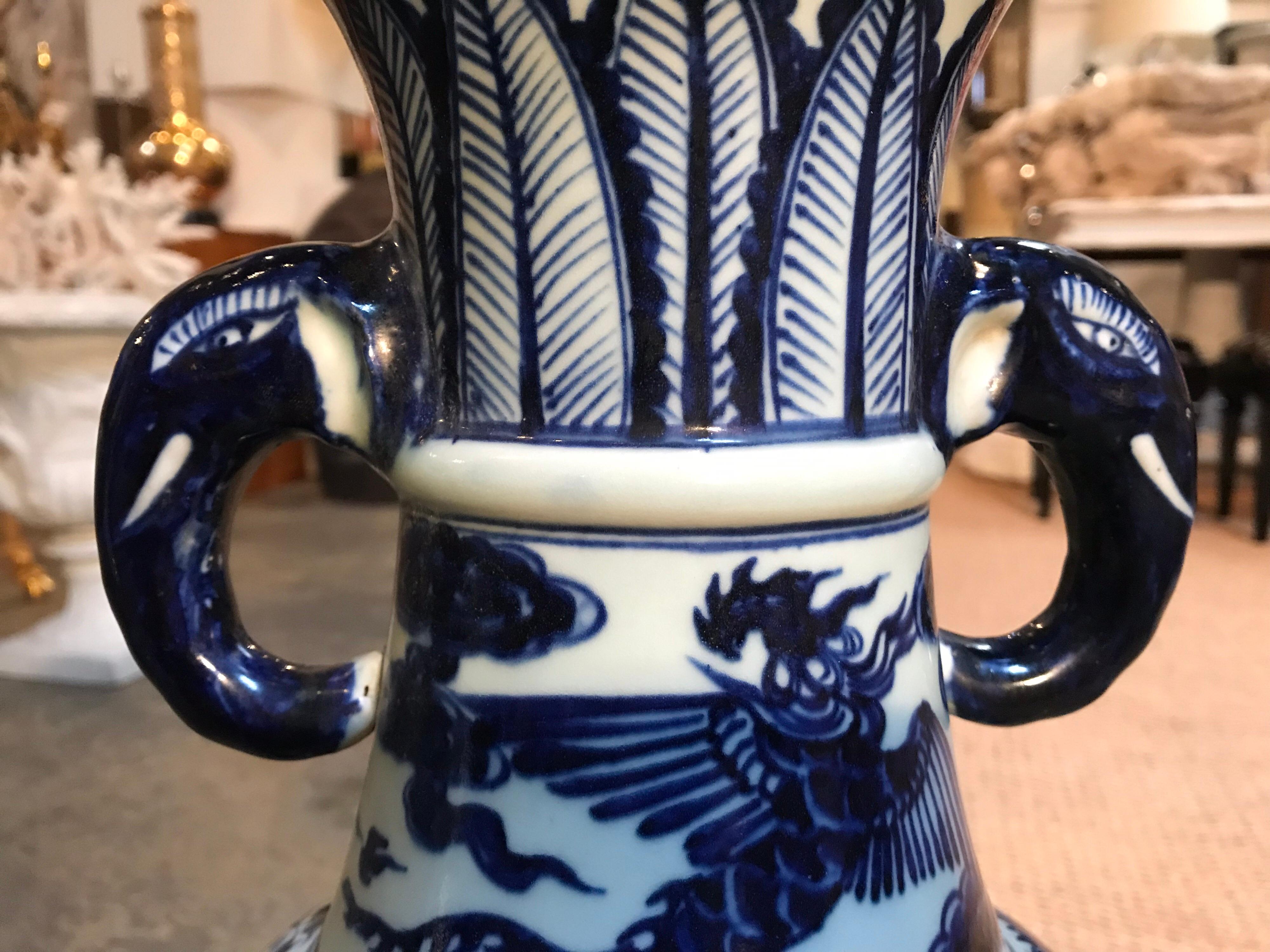 This pair of blue and white ceramic vases has classical Chinese dragon themes patterning the exterior of the piece. The handles draw interest because they were creatively fashioned into the shape of a elephant heads.