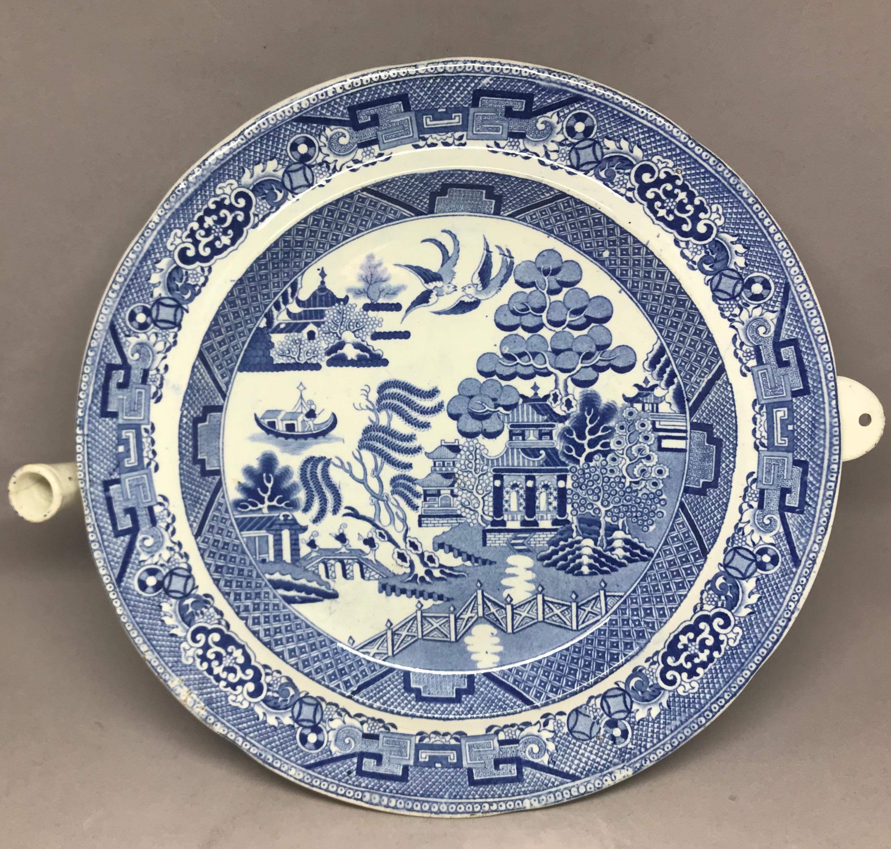 Blue and white willow pattern warming dish. Antique transfer willow pattern with deep warming chamber for hot water with spout. England, circa 1820-1840. 
Dimension: Dish 10