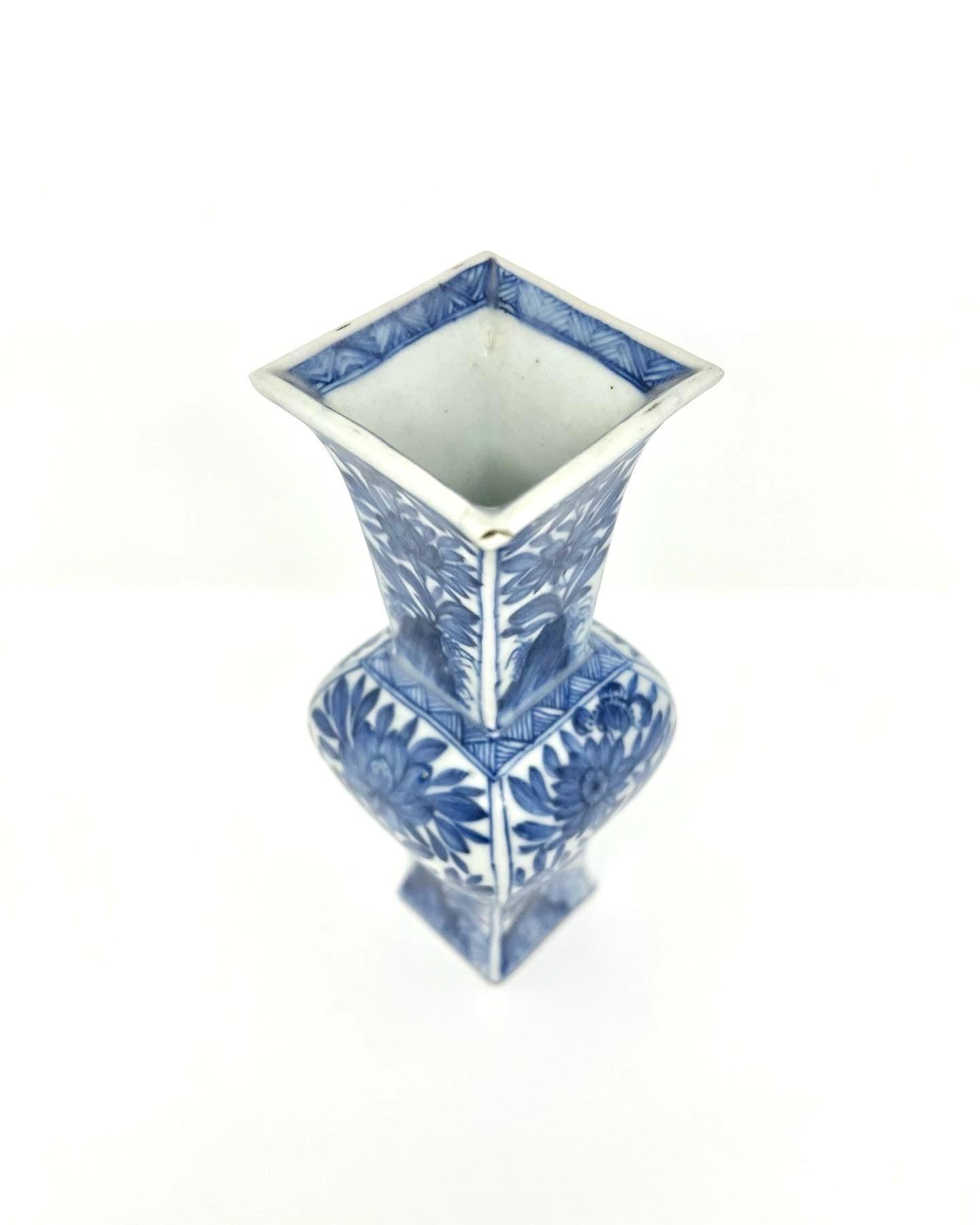 Each side pencil-painted with stylized chrysanthemum, lotus or daisy sprays issuing from rockwork. This blue and white square vase with rounded sides has a flaring mouth and a long neck. This shape can be traced back to Chinese bronzes. It is
