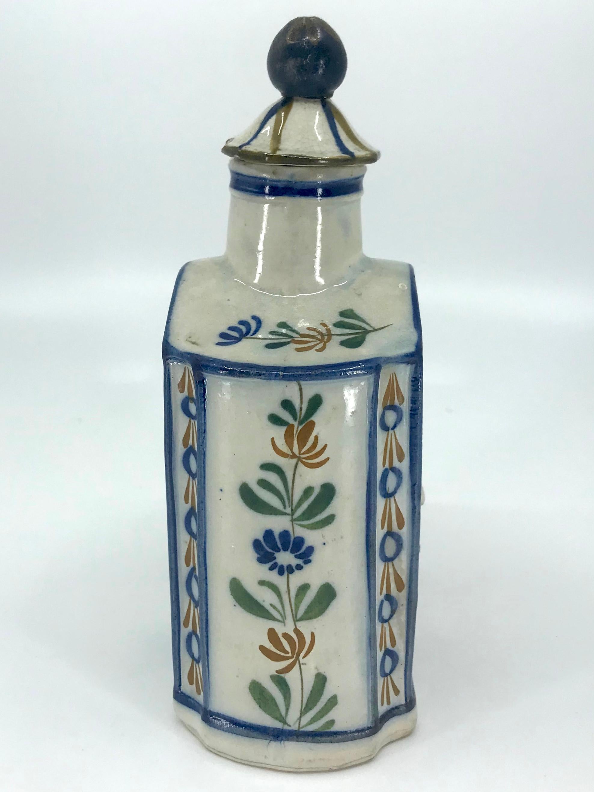 Blue and yellow chinoiserie tea caddy. Charming Prattware shaped tea canister in a blue cast paste with blue, yellow and moss green decoration featuring a chinoiserie figure in high relief and floral details on end panels with blue outlines; with an
