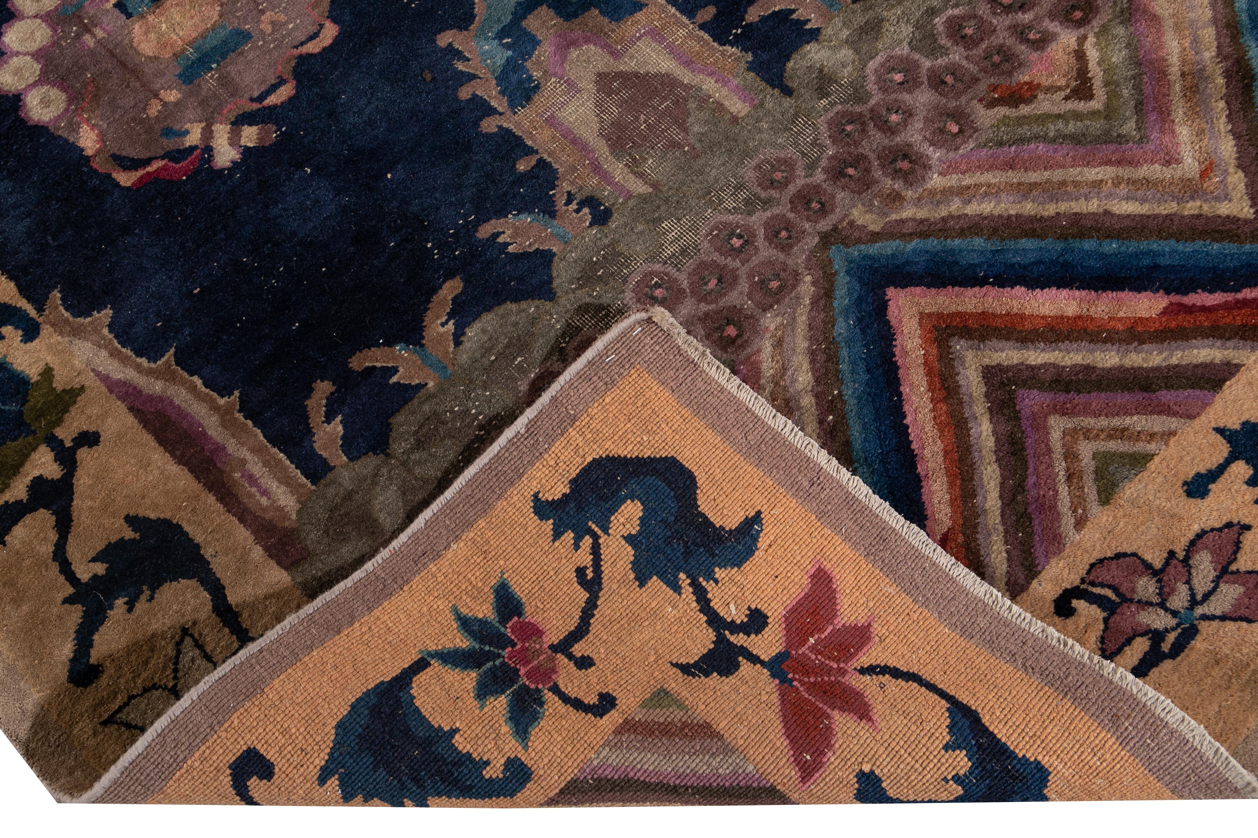 Beautiful antique Art Deco Chinese hand knotted wool rug with Navy-blue field. This rug has a frame of beige and accents of red, purple, and green in a gorgeous all-over Chinese floral design.

This rug measures 5'9