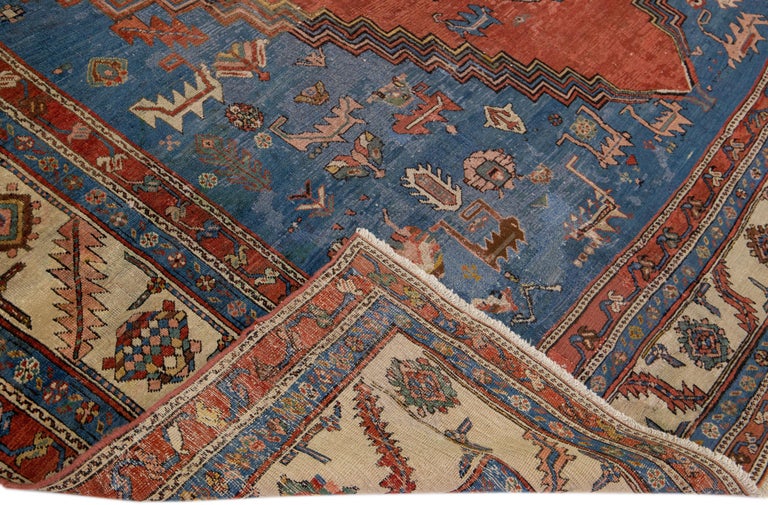 Beautiful antique Bakshaish hand-knotted wool rug with rust and blue field. This piece has a beige frame and multicolor accents on a gorgeous Classic medallion design.

This rug measures 11'8