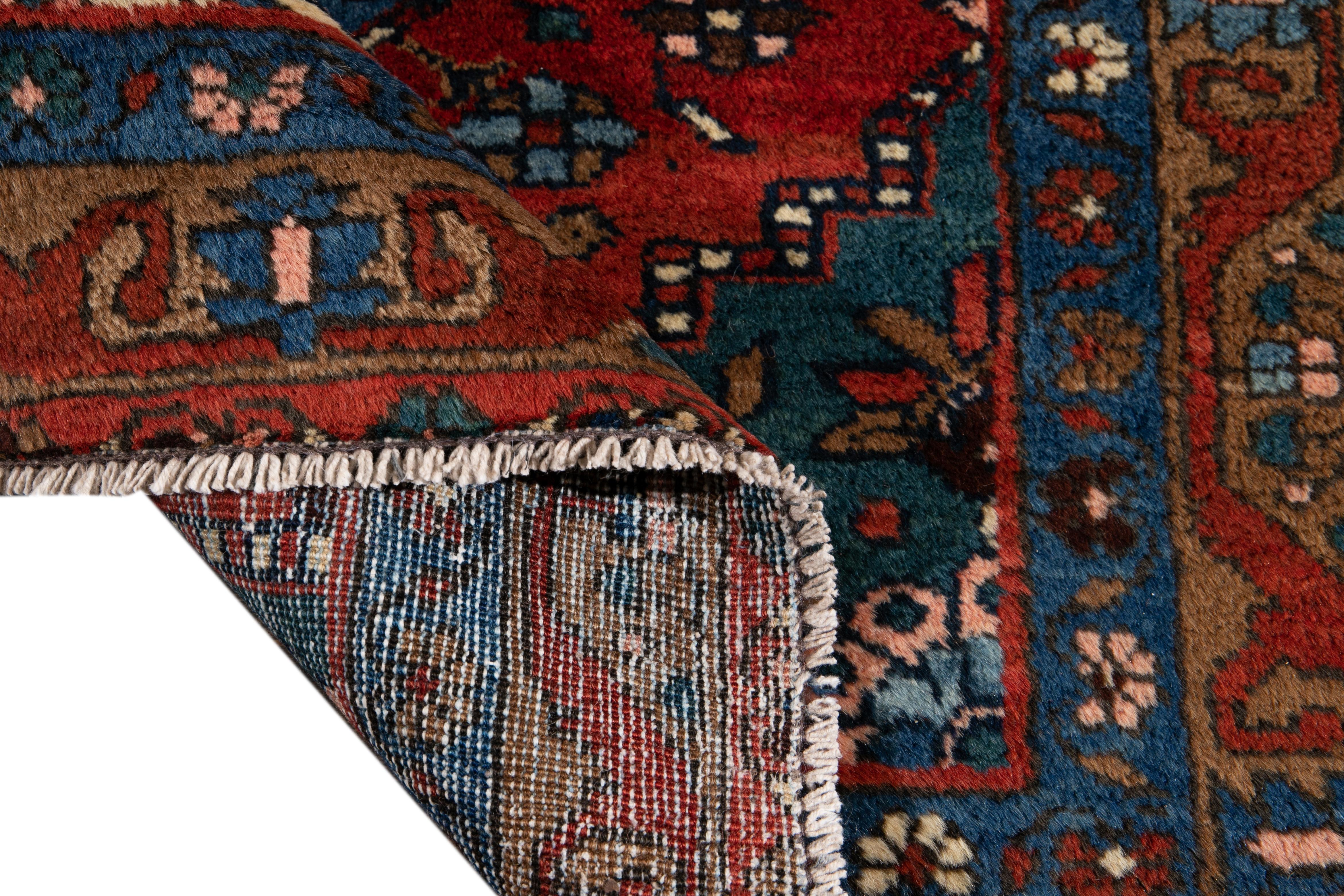 Beautiful antique Heriz hand knotted wool runner with a blue and red field. This Heriz runner has accents in brown and rose in a gorgeous all-over geometric floral medallion design.

This rug measures: 3'5