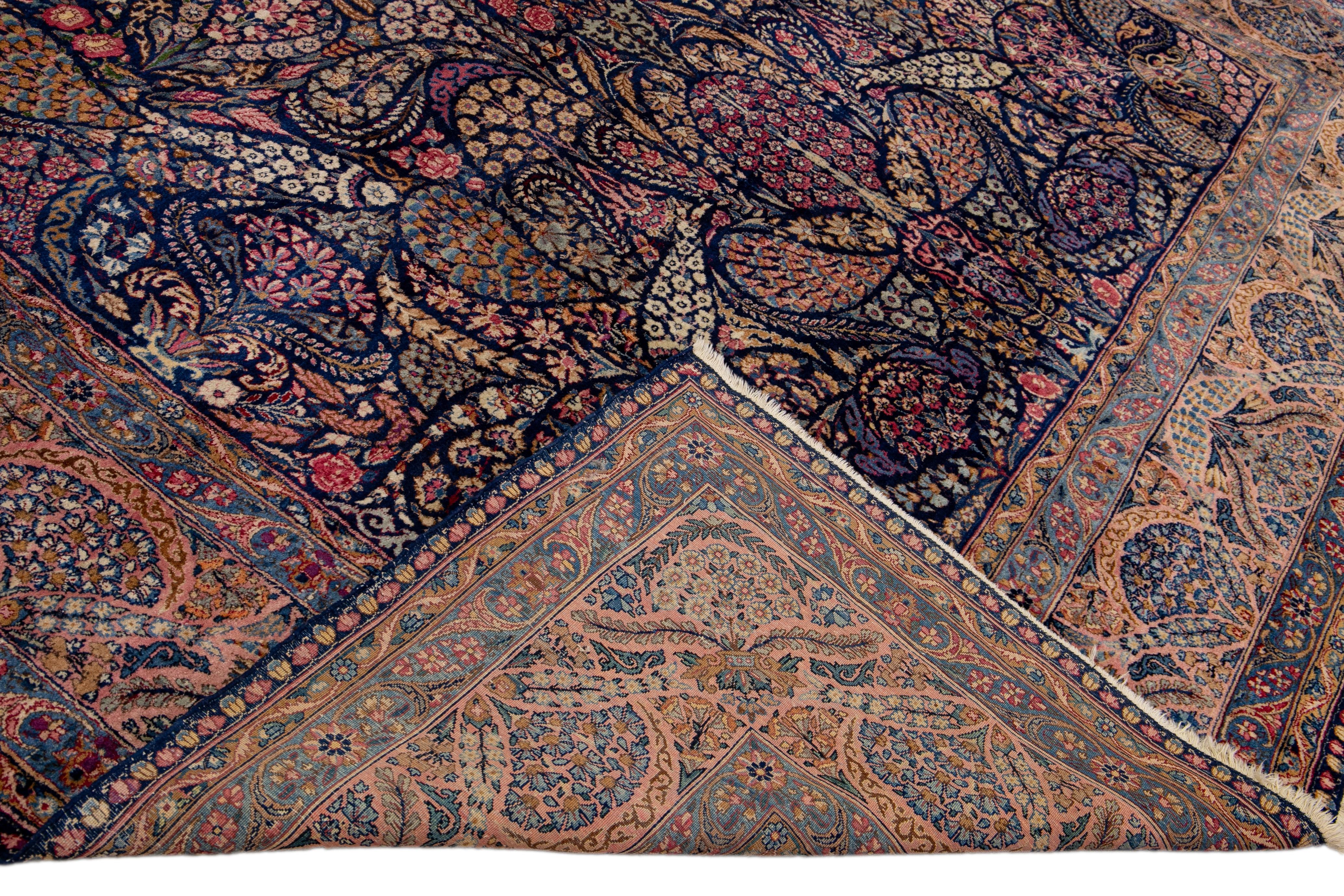 Schöne antike Kerman handgeknüpften Wollteppich mit der marineblauen Feld. Dieser Perserteppich hat einen gestalteten Rahmen und mehrfarbige Akzente in einem prächtigen, floralen Allover-Muster. 

Dieser Teppich misst: 9'5