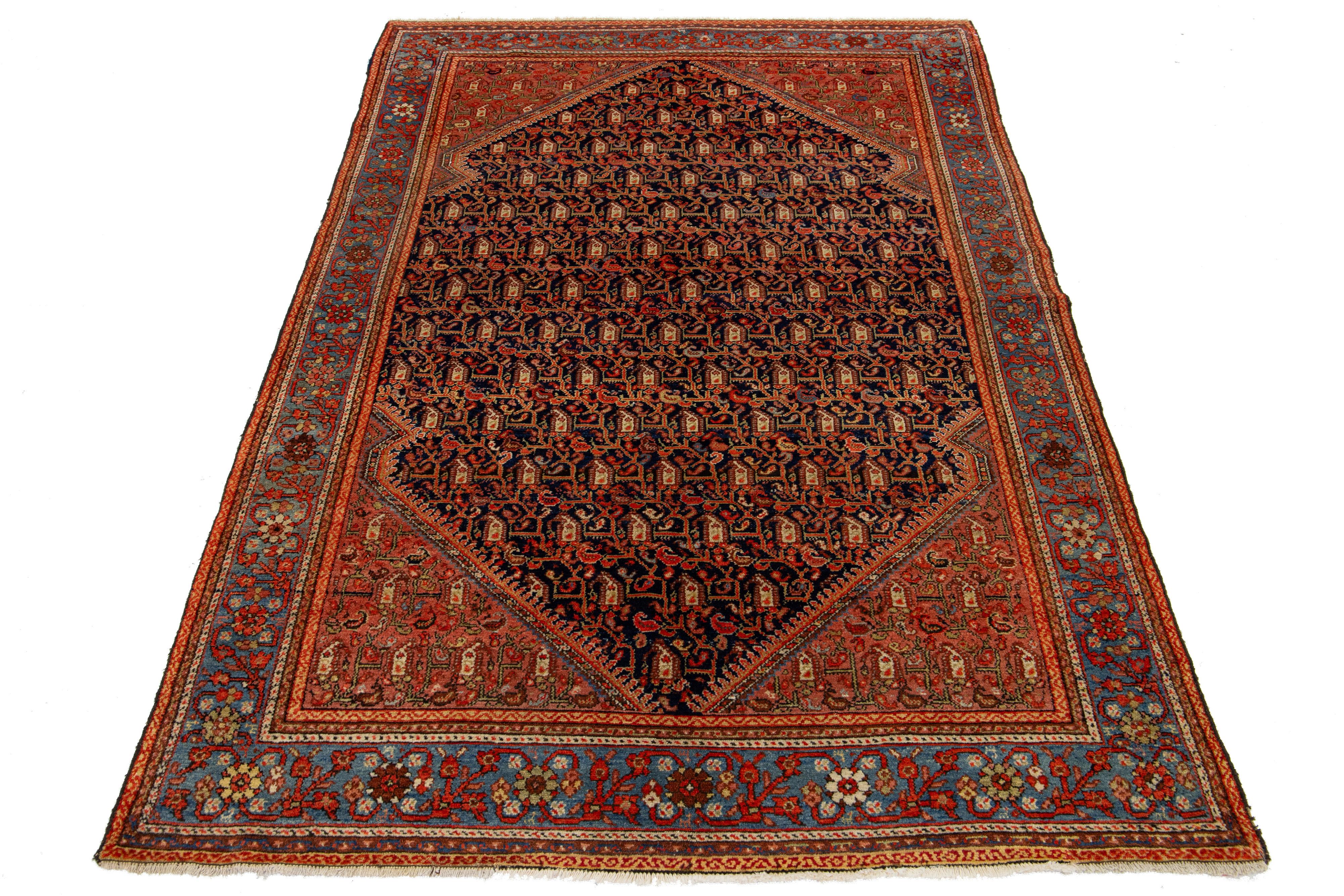 Il s'agit d'un tapis persan Malayer du 20e siècle, fait à la main, présentant un champ bleu marine avec des accents de beige et de rouille orange sur l'ensemble du motif.

Ce tapis mesure 4'5
