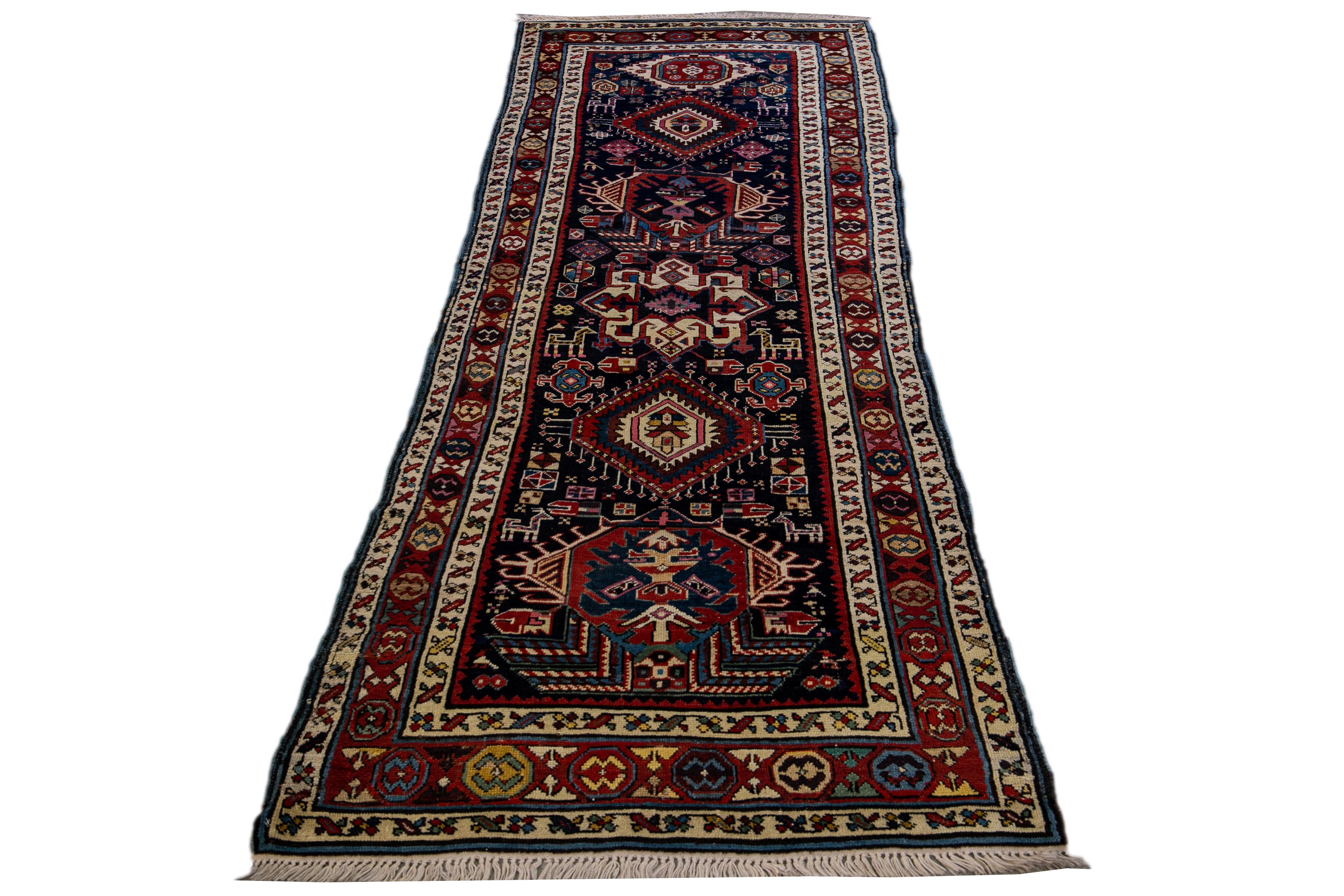 An Antique North West Persian runner rug featuring a tribal motif in navy blue. This piece exhibits exquisite details, vibrant colors, and a stunning design.

This rug measures 3'4