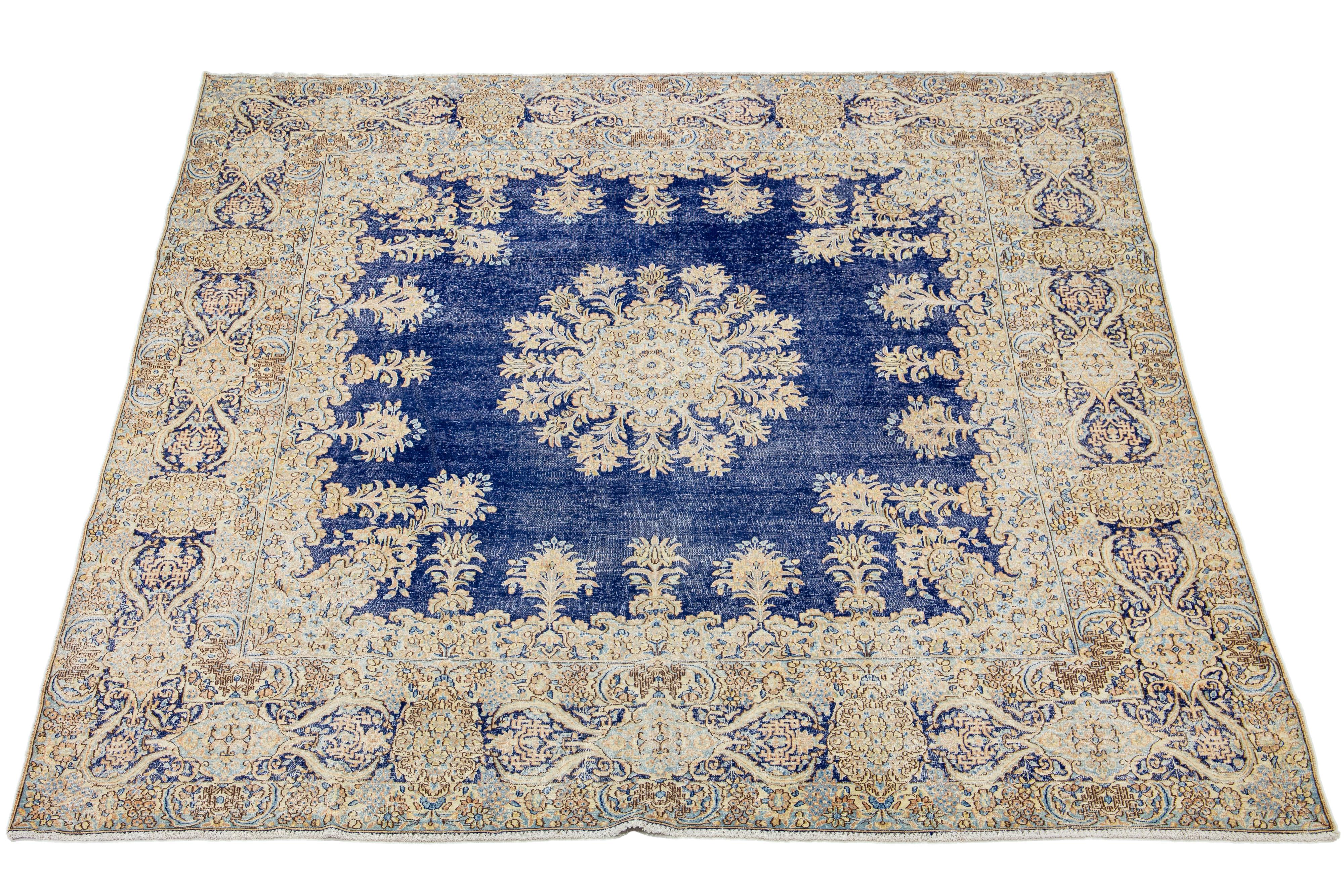 This Persian Kerman wool rug from the late 19th century showcases a meticulously crafted all-over floral design in beige, yellow, and peach. It also features a blue field.

This rug measures 9'9