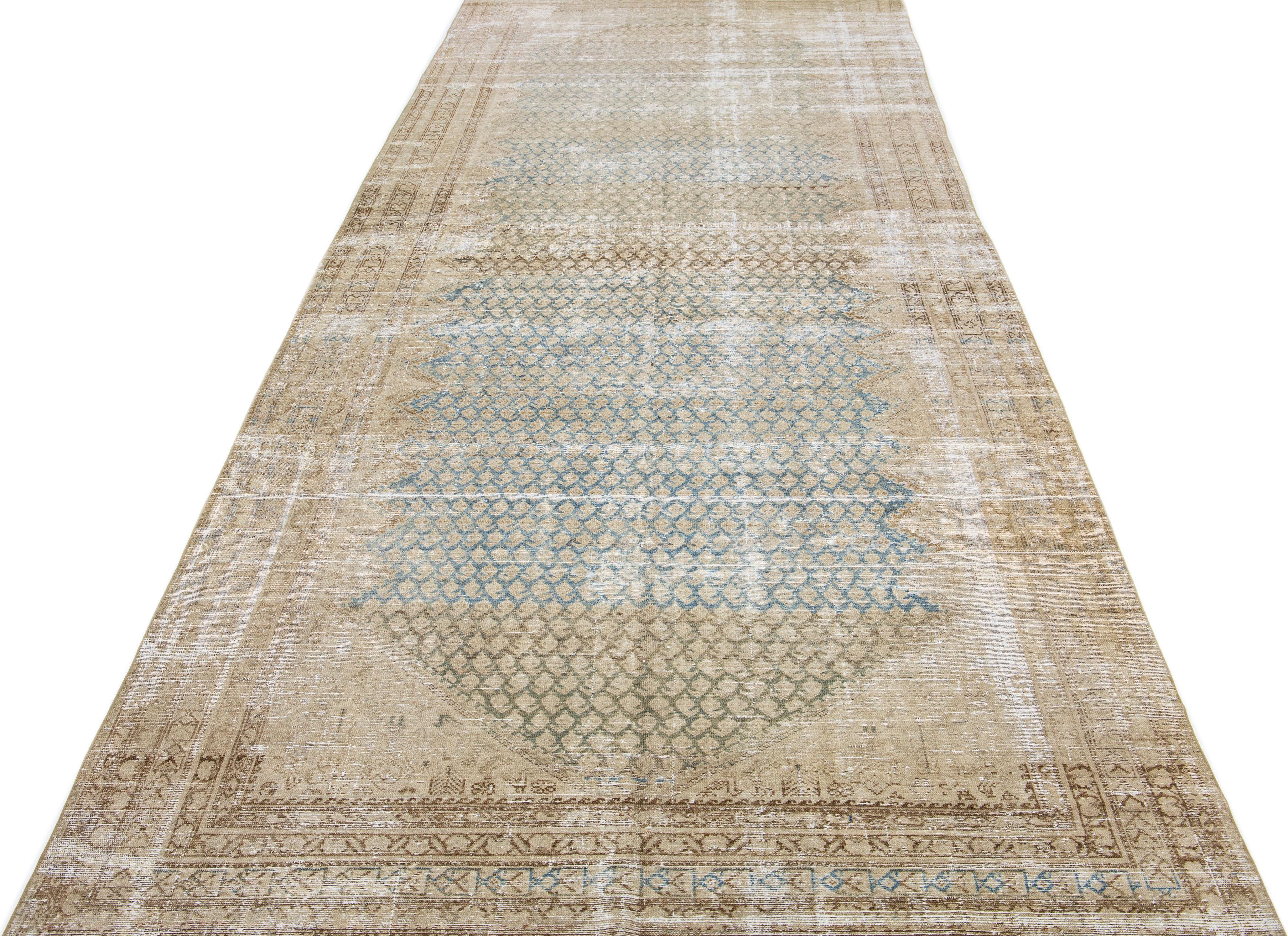 Beautiful antique Malayer hand-knotted wool runner with a beige color field. This Persian piece has blue and brown accents in an all-over geometric pattern. 

This rug measures: 6'3