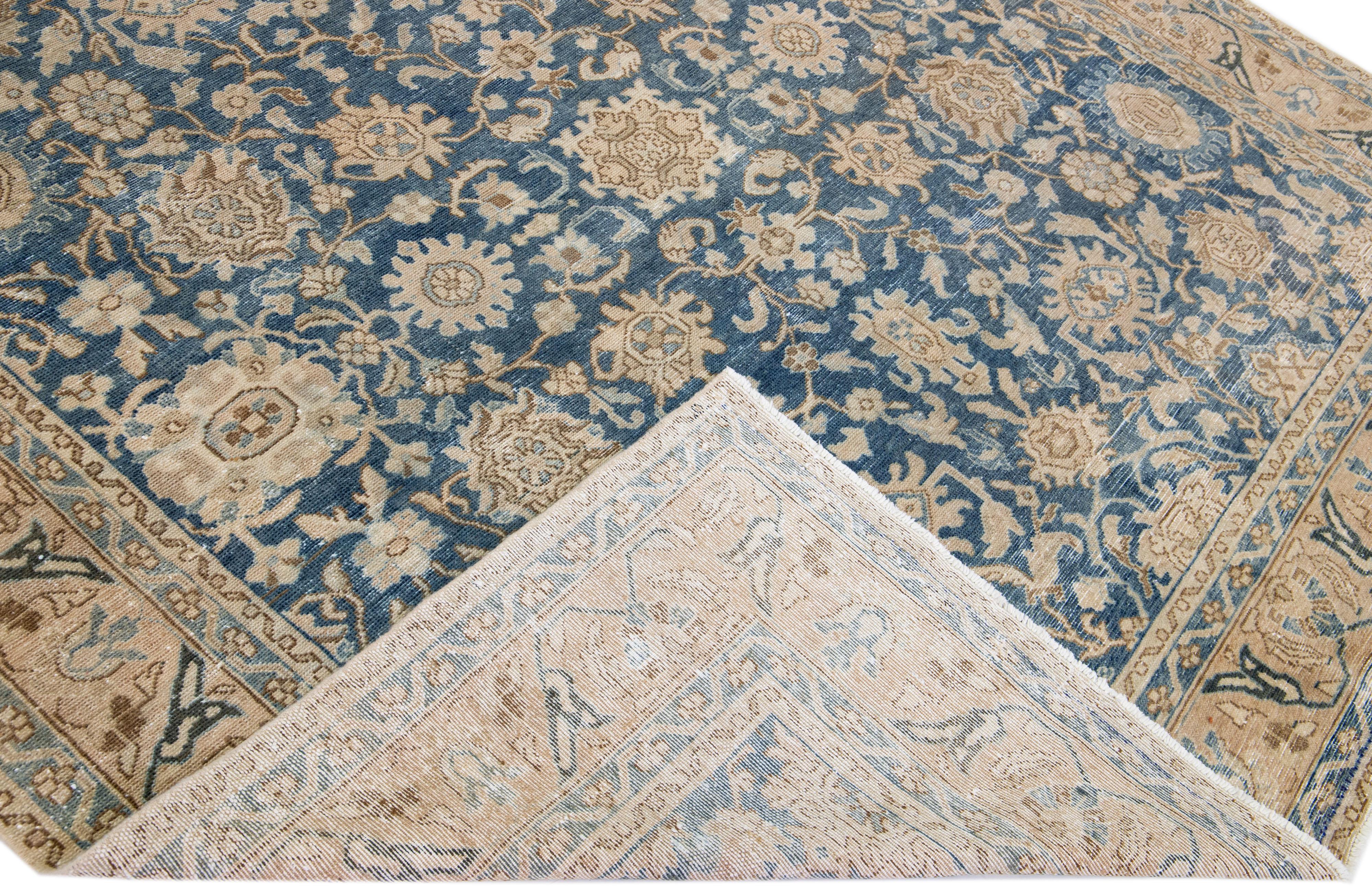 Beautiful Antique Malayer hand-knotted wool rug with a blue color field. This Persian rug has a beige frame and accents in a gorgeous all-over floral motif.

This rug measures 7'2