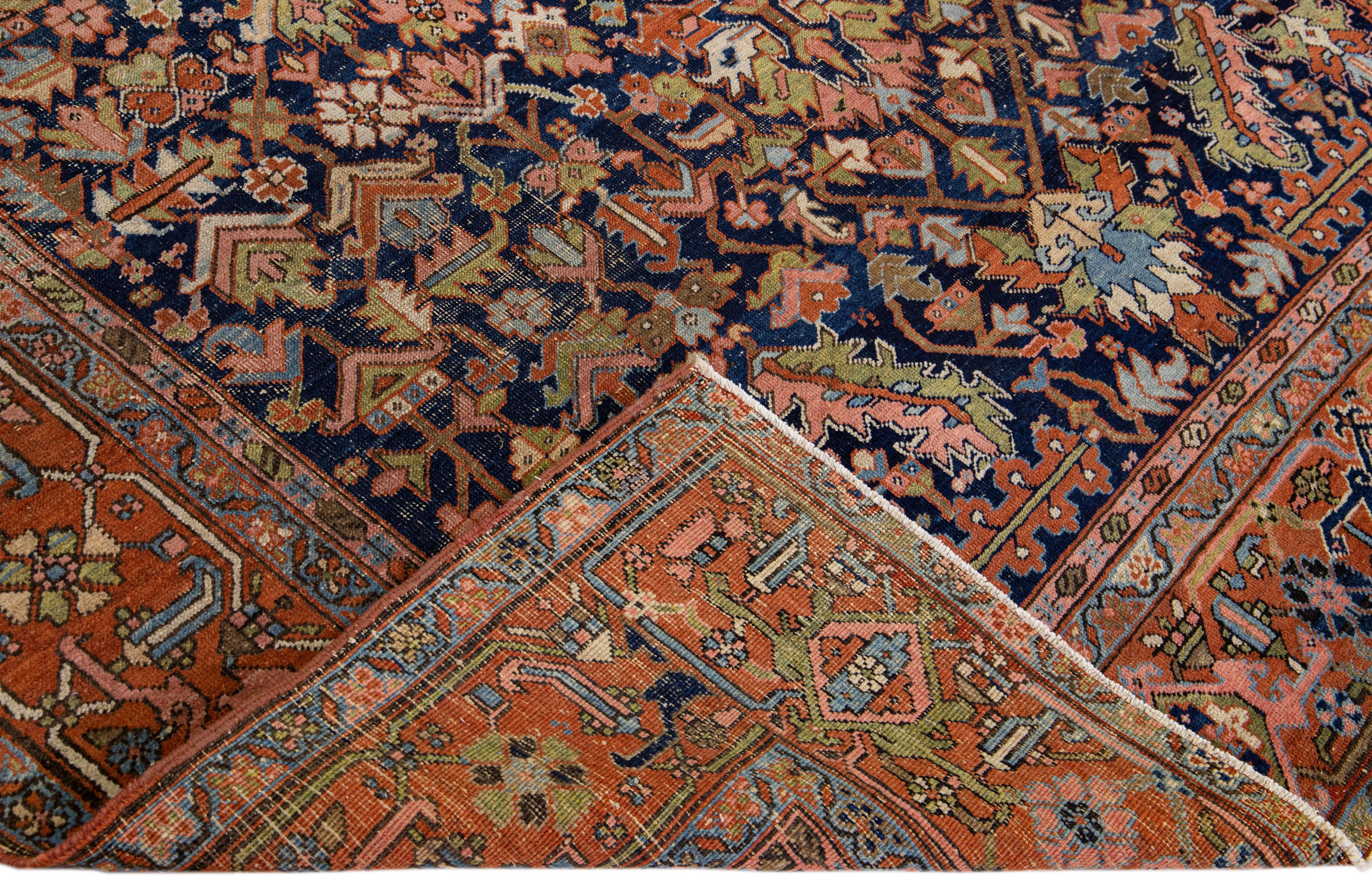 Beautiful antique Heriz Serapi hand-knotted wool rug with a blue field. This Heriz rug has an orange-rust designed frame and multi-color accents in a gorgeous all-over floral design.

This rug measures: 8'10