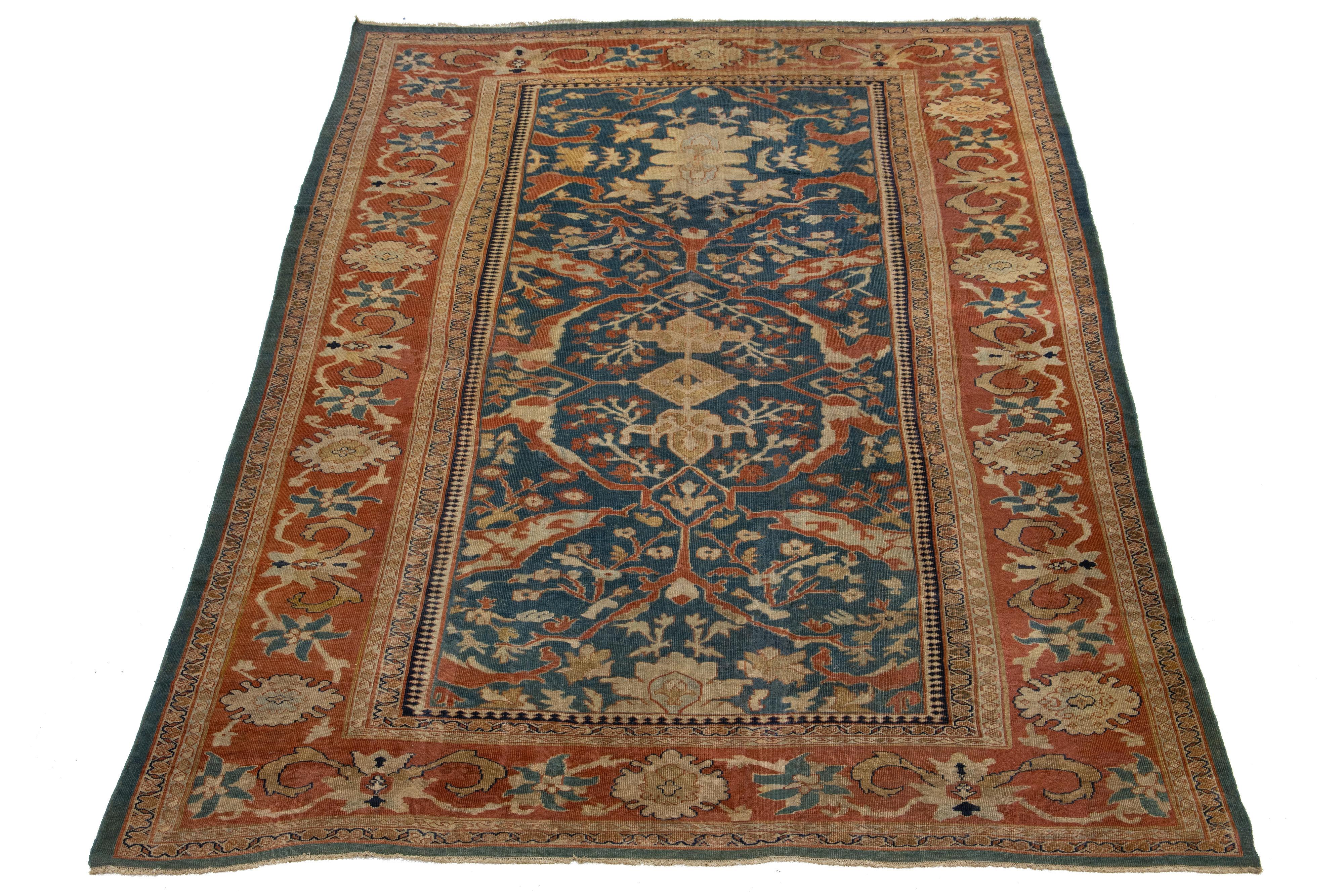 Découvrez l'élégance d'un tapis Sultanabad antique noué à la main, présentant un motif captivant aux accents orange-rouille et beige vibrants sur un luxueux fond bleu marine.

Ce tapis mesure 9'9