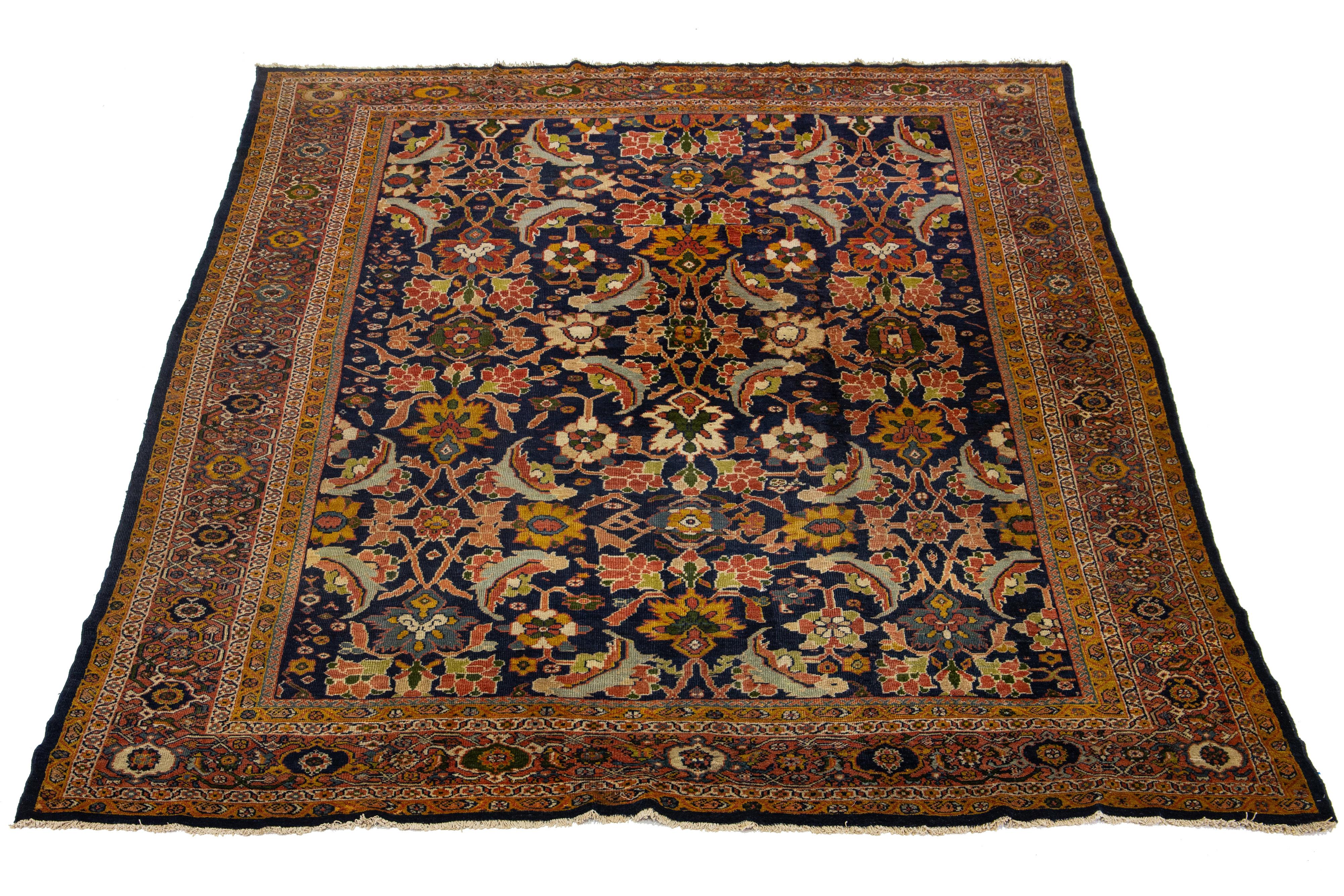 This antique Sultanabad wool rug from the 1880s is a stunning hand-knotted piece with a blue field. It displays multicolored accents in a floral design. The enduring quality of this classic rug design is emphasized by its strong wool weave, which is