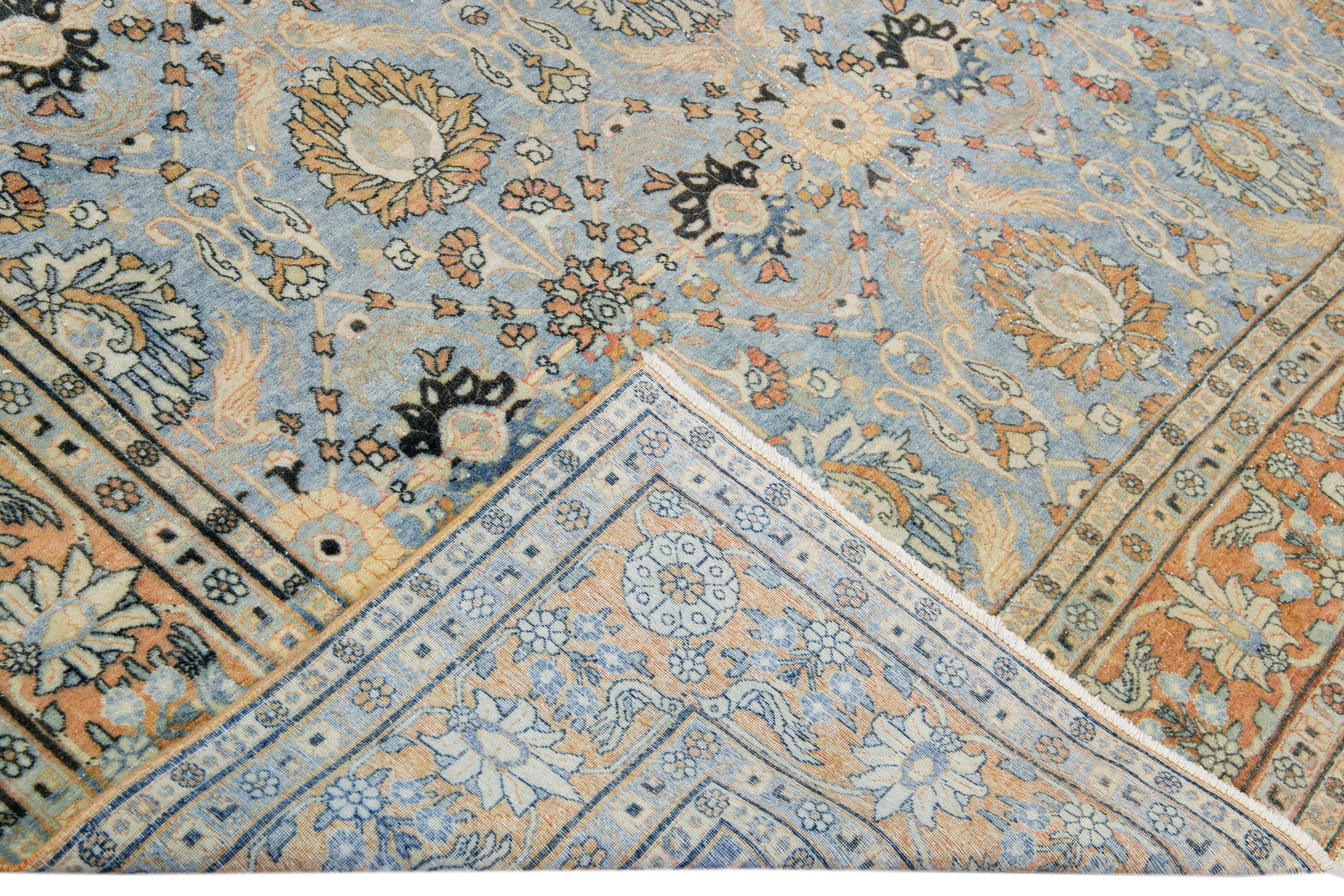 Beautiful antique Persian Tabriz hand-knotted wool rug with a blue field. This piece has a rusted frame and accent in an all-over gorgeous floral design.

This rug measures: 7' x 10'6