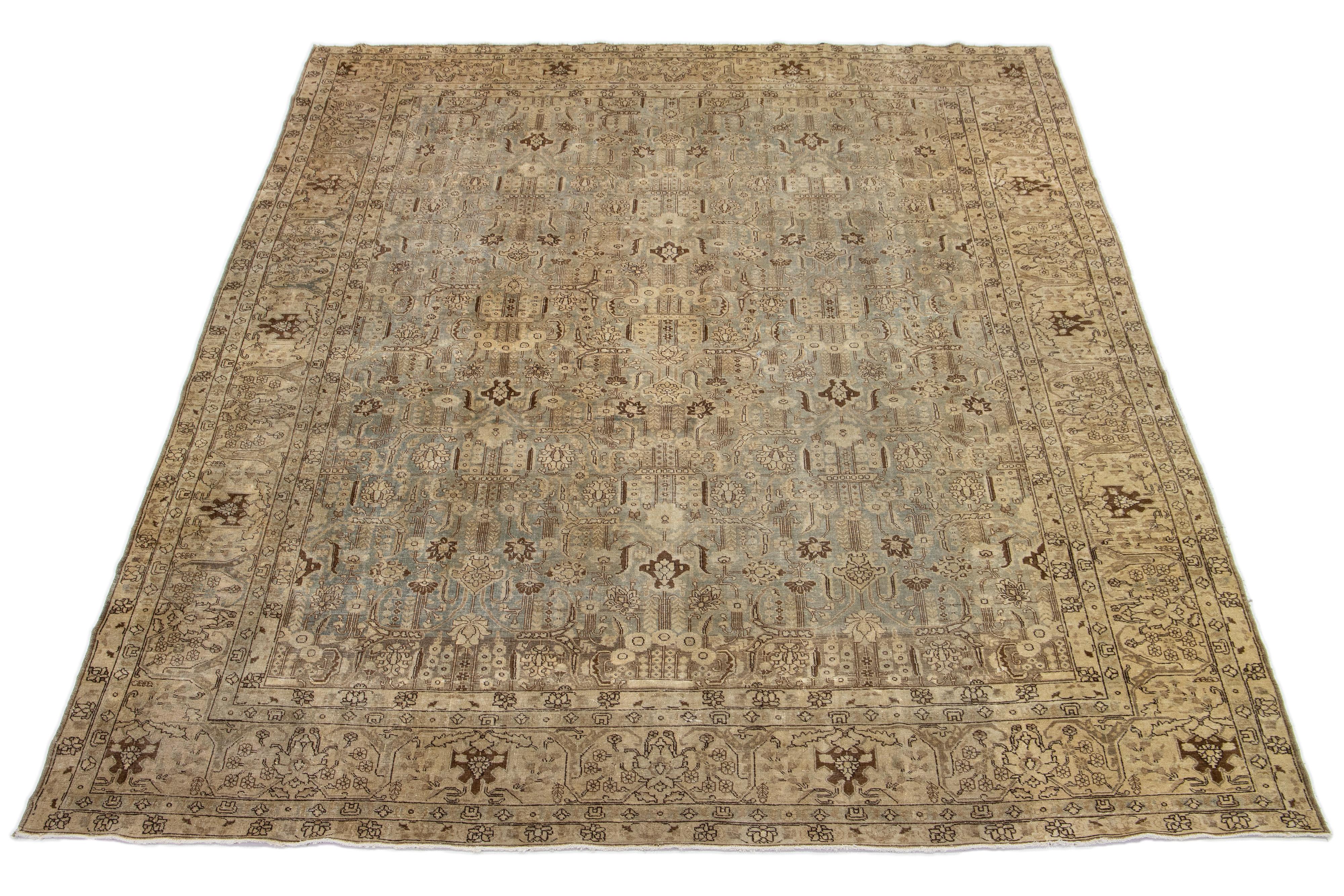 Ce tapis persan en laine Tabriz est magnifiquement noué à la main et présente un motif floral classique sur un fond bleu pâle, accentuant les nuances de beige et de marron du motif.

Ce tapis mesure  10'2