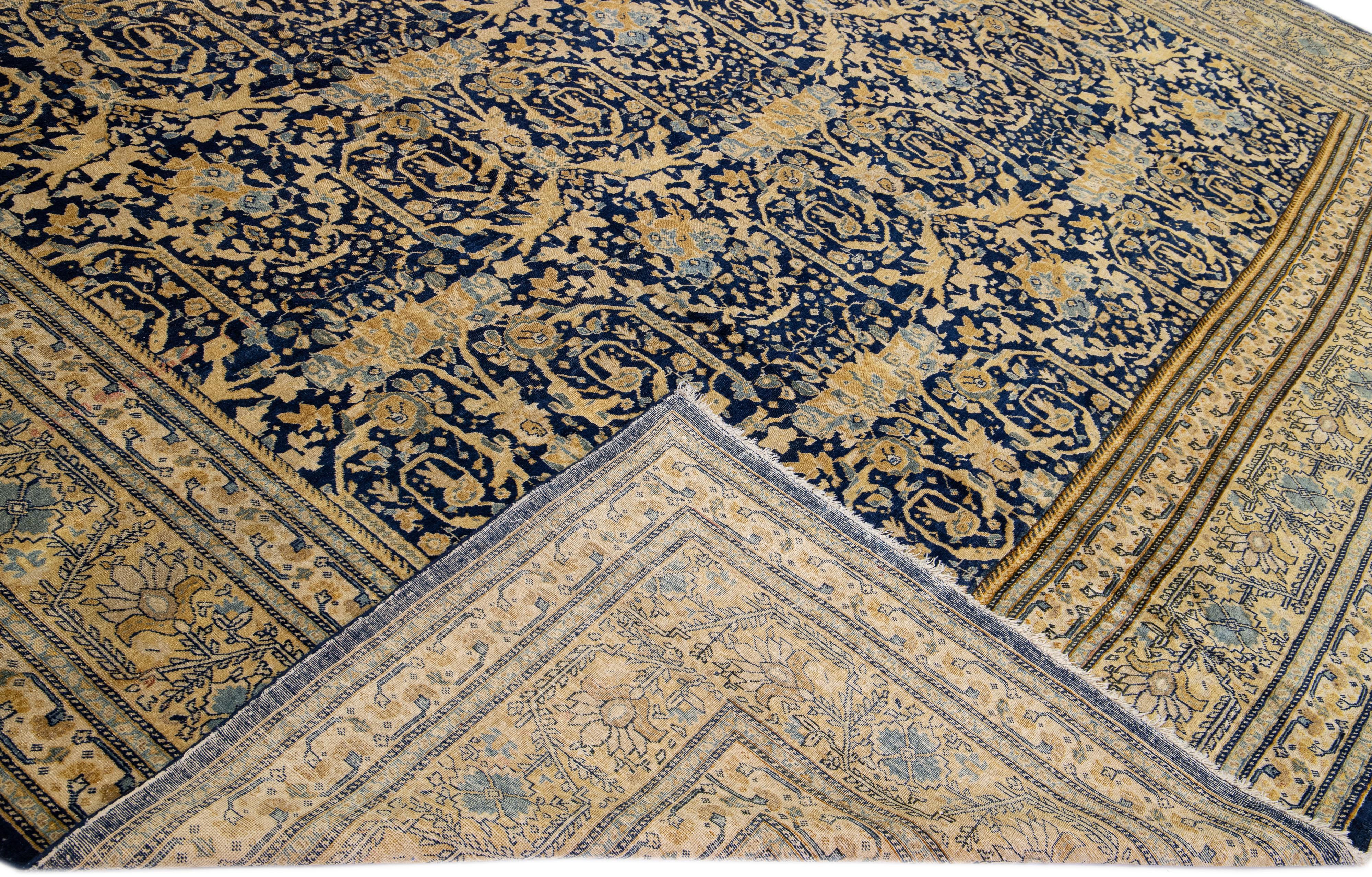Beautiful antique Tabriz hand-knotted wool rug with a blue field. This Persian piece has brown and beige accents in a gorgeous all-over floral design. 

This rug measures: 12'7