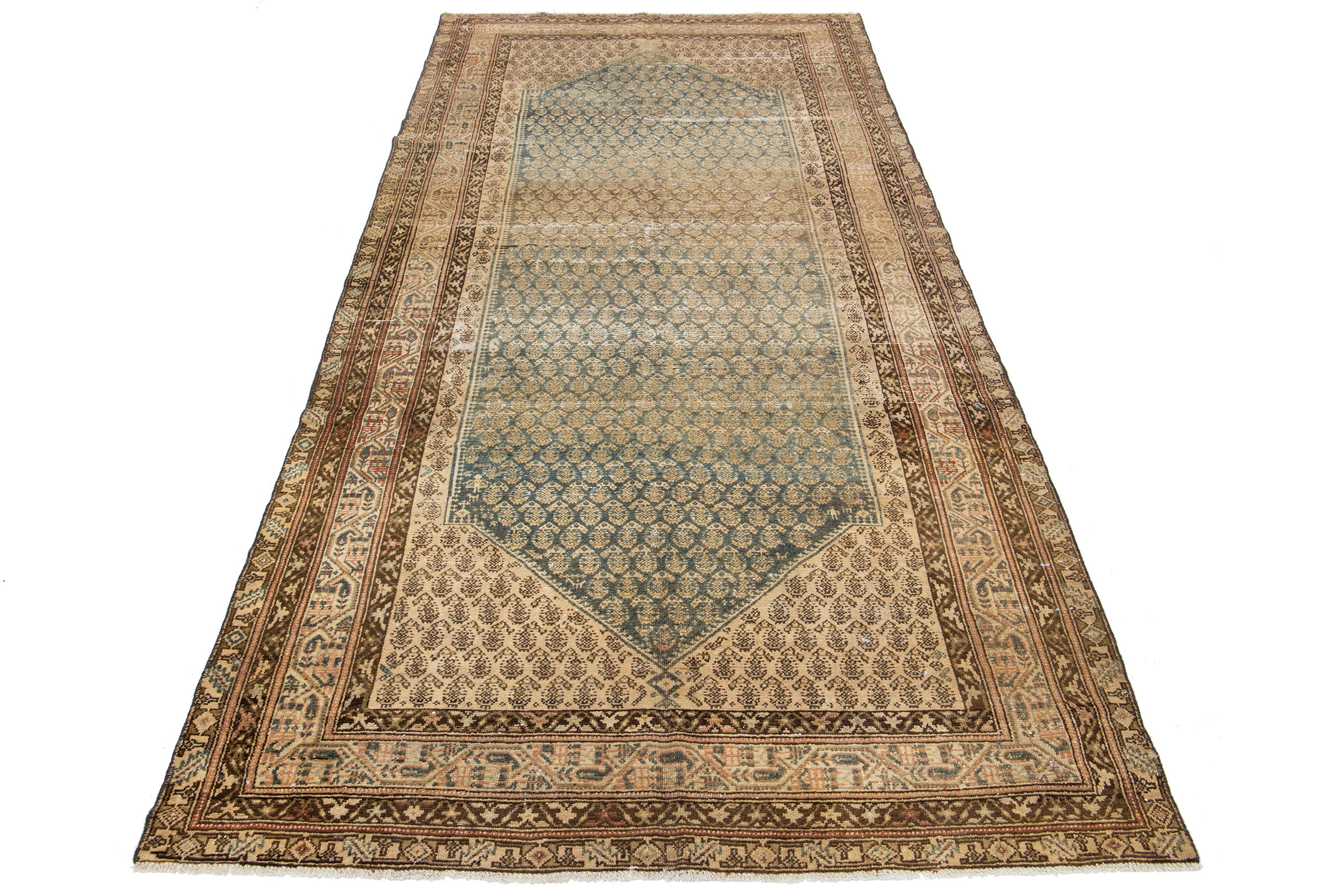 Beautiful antique Malayer hand-knotted wool rug featuring a blue color field. This Persian rug showcases a stunning all-over design with beige and brown accents.

This rug measures 4'11