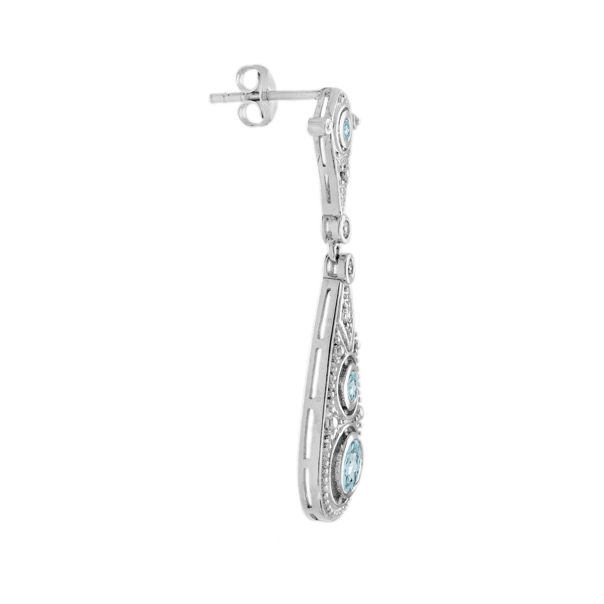 A bright sparkling pair of aquamarine and diamond, delicately hand crafted in 18k white gold with decorative openwork and fine milgrain details in emulation of Edwardian design. 14K White Gold. 
Earrings Information
Style: Edwardian
Width: 10