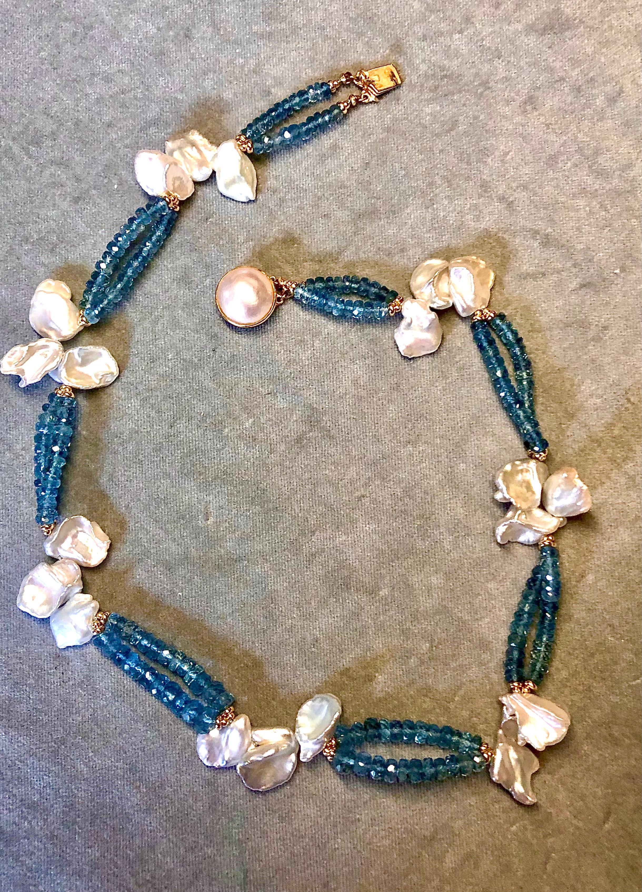 Double strand necklace of Santa Maria deep blue  aquamarine rondelles with very lustrous large white baroque Keishi pearls flanked with 14kt yellow gold smooth rondelles . Finished with fine Mabe pearl and 14kt yellow gold clasp. 16” in length.