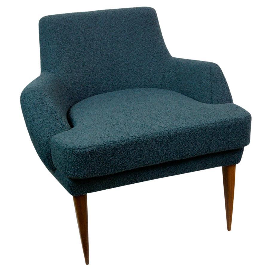 This Austrian Midcentury cozy and highly comfortable blue boucle fabric Lounge Chair was designed by one of the the most important Austrian Post War Architects Oswald Haerdtl, who studied and worked together with Josef Hoffmann. 
The Chair features