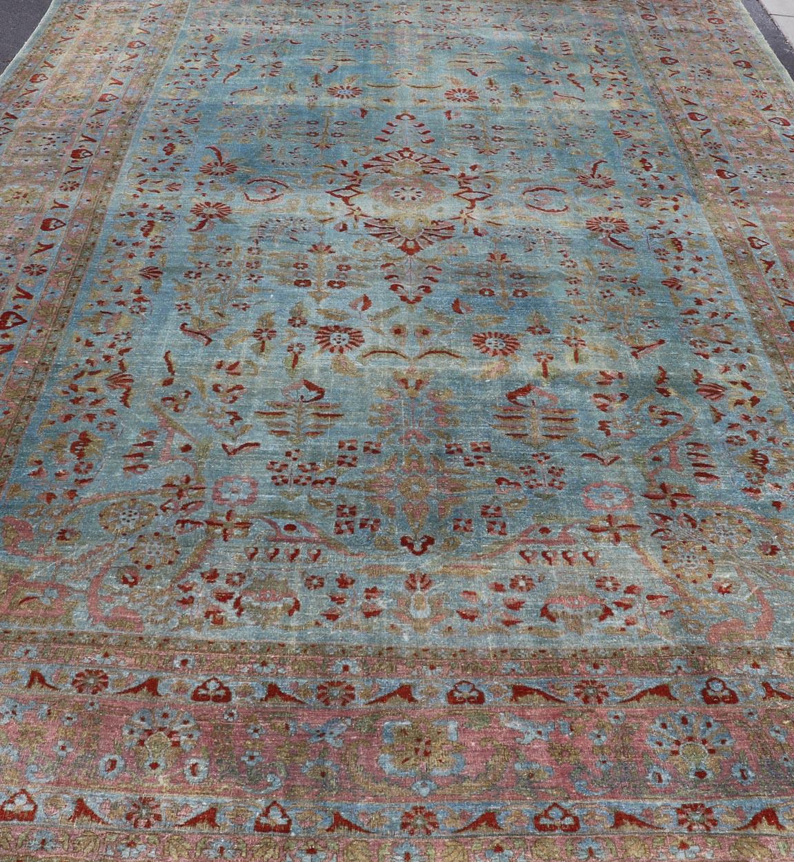 Antiker persischer Mohajerah-Teppich mit blauem Hintergrund und Lachsblau, Grün und Rot (20. Jahrhundert) im Angebot