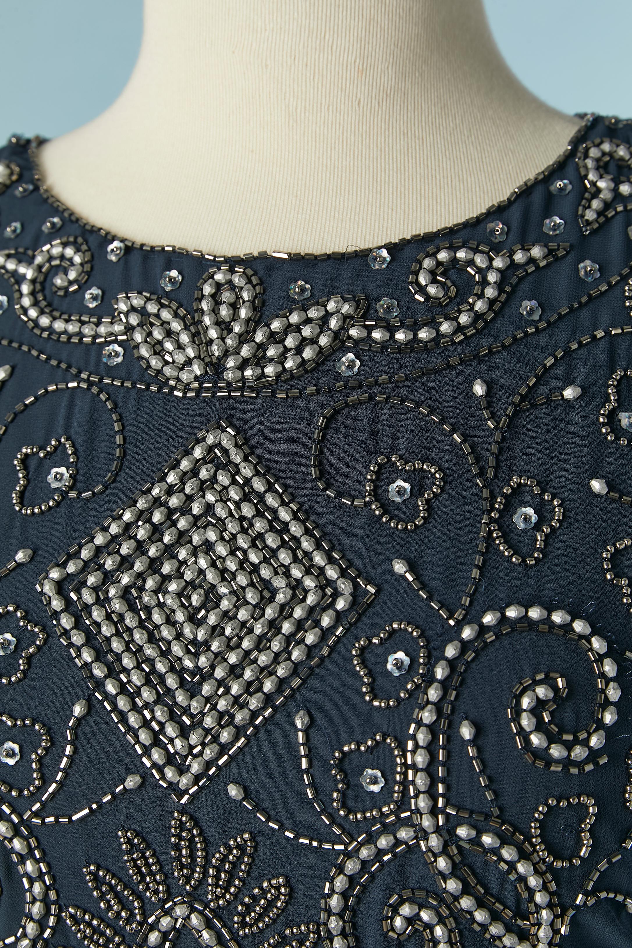 Blue beaded backless evening dress. Shell composition and lining: 100% polyester. 
Hook&eye and zip closure on the middle back. 
SIZE S 
