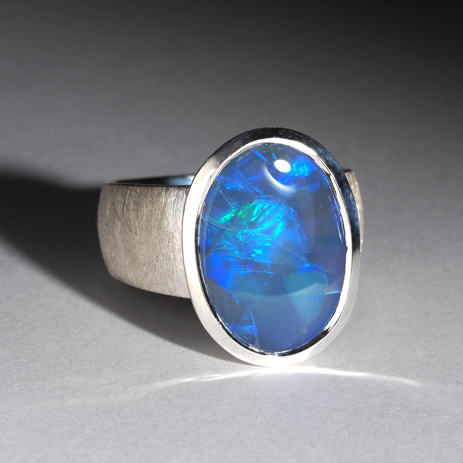 Questo squisito anello presenta un'affascinante opale blu incastonata nell'argento sterling. L'opale vanta un motivo straordinario, unico nel suo genere, e un'opalescenza bellissima e vibrante che cambia con la luce. È un vero e proprio pezzo forte,