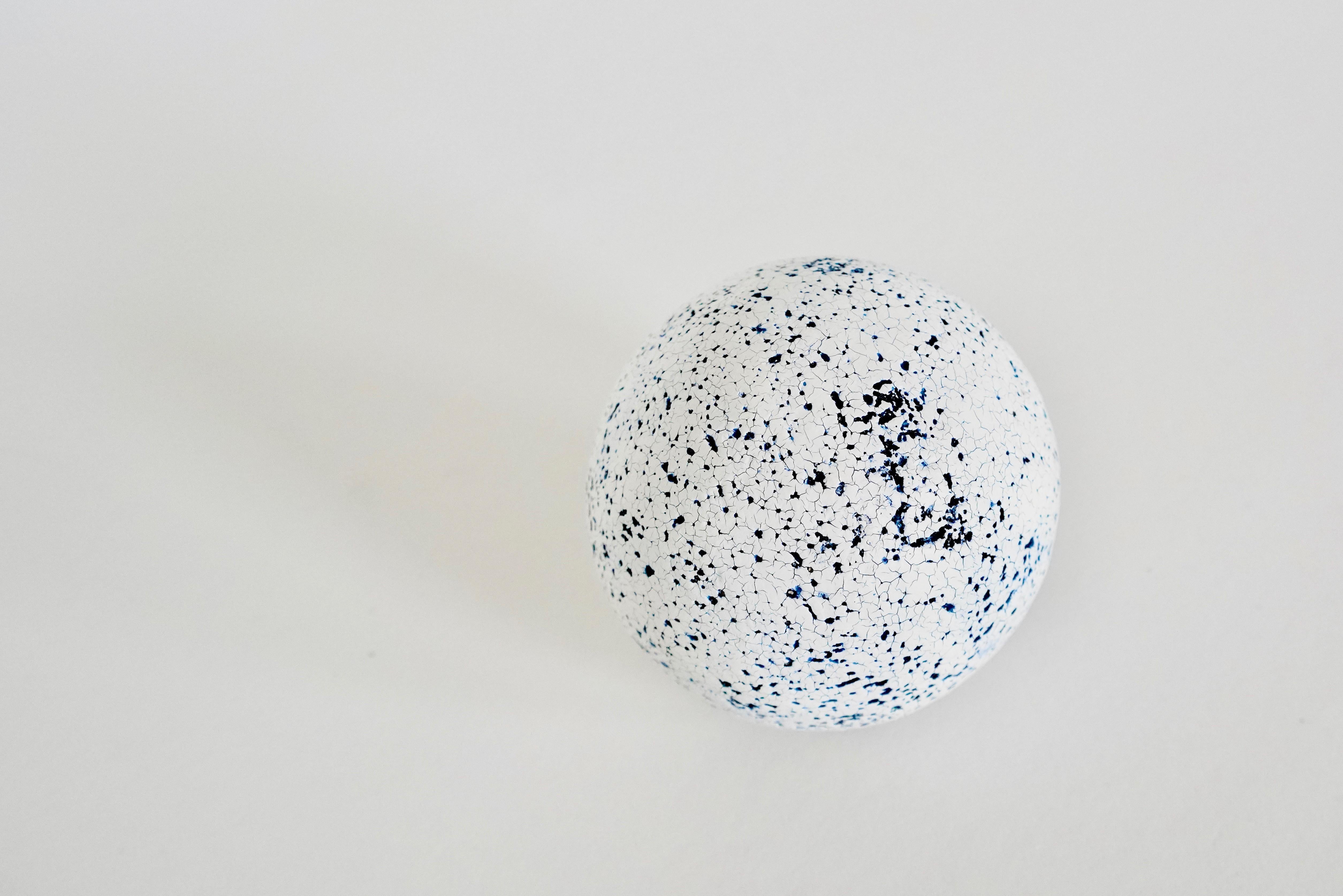 Blue, black and white ceramic sphere. This 3-inch piece is coated in many layers of 