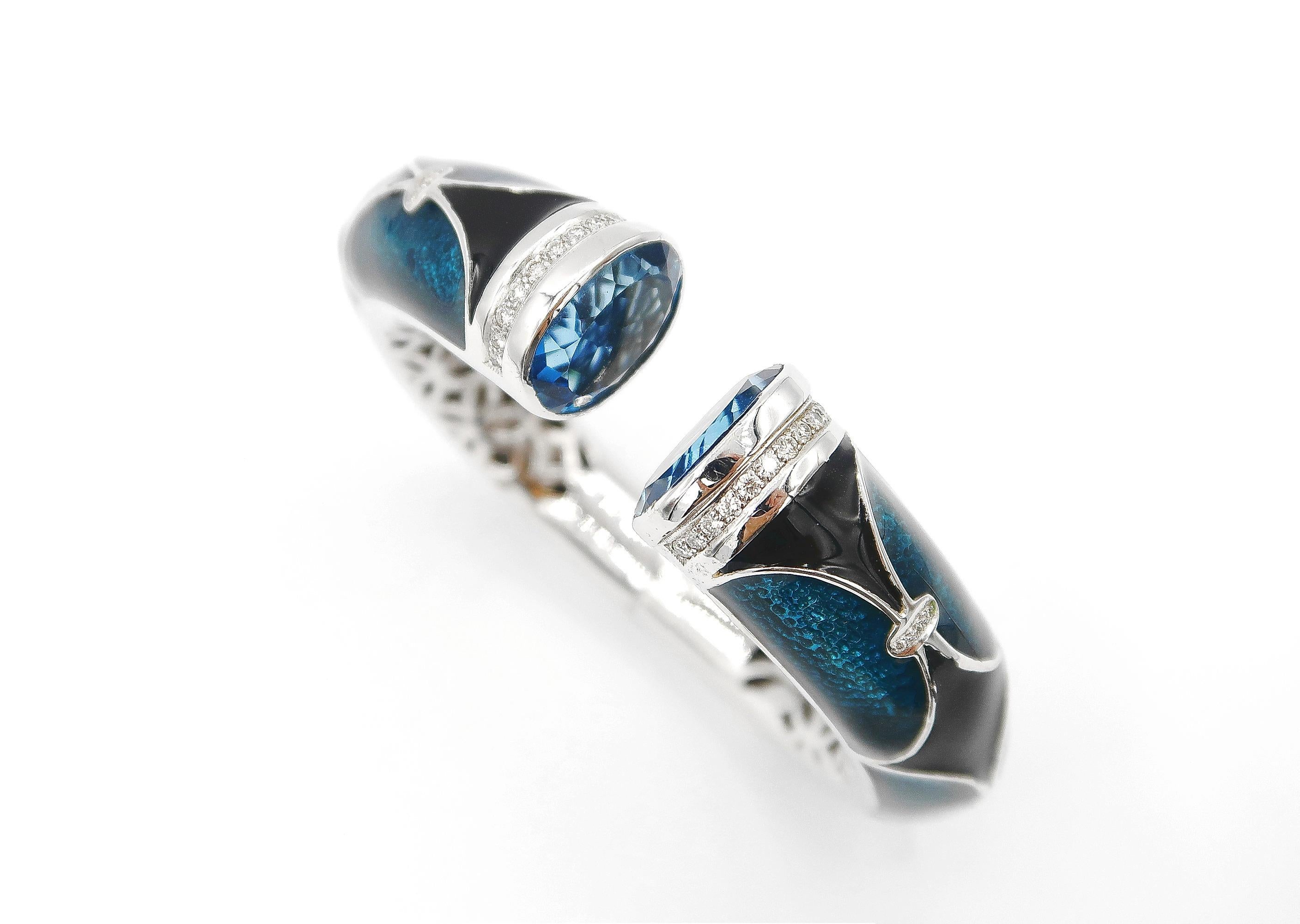 Blue and Black Enamelled, Blue Topaz, and Diamond Clamper Bangle in 18K Gold 

Metal: 18K Gold, 75.98 g
Blue Topaz: Oval, 25.07 ct
Diamond: Round Brilliant, 0.70 ct