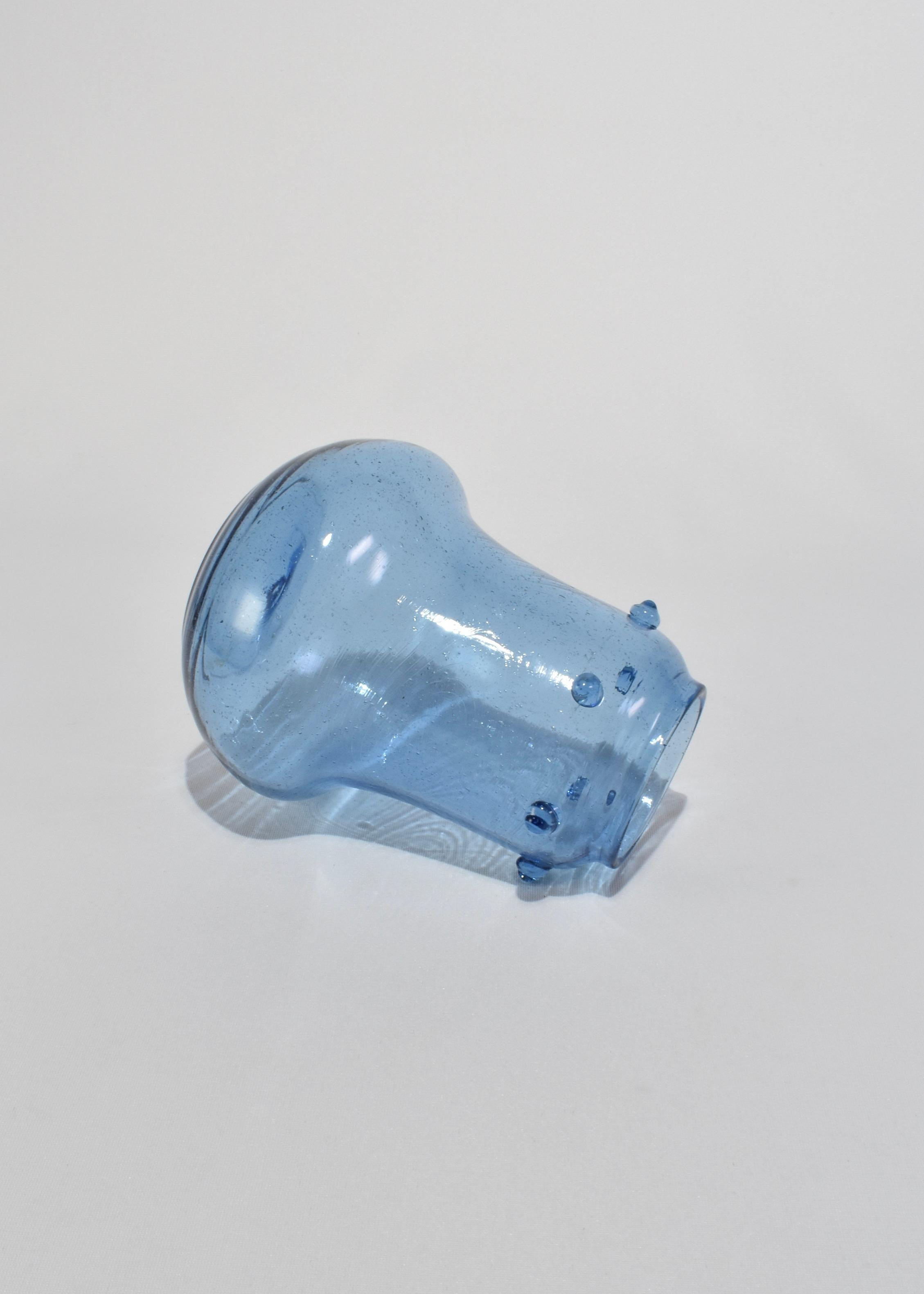 Un vaso minimalista in vetro soffiato blu, ornato da punti di vetro applicati e da intricate bolle controllate, che creano un bellissimo effetto strutturato.